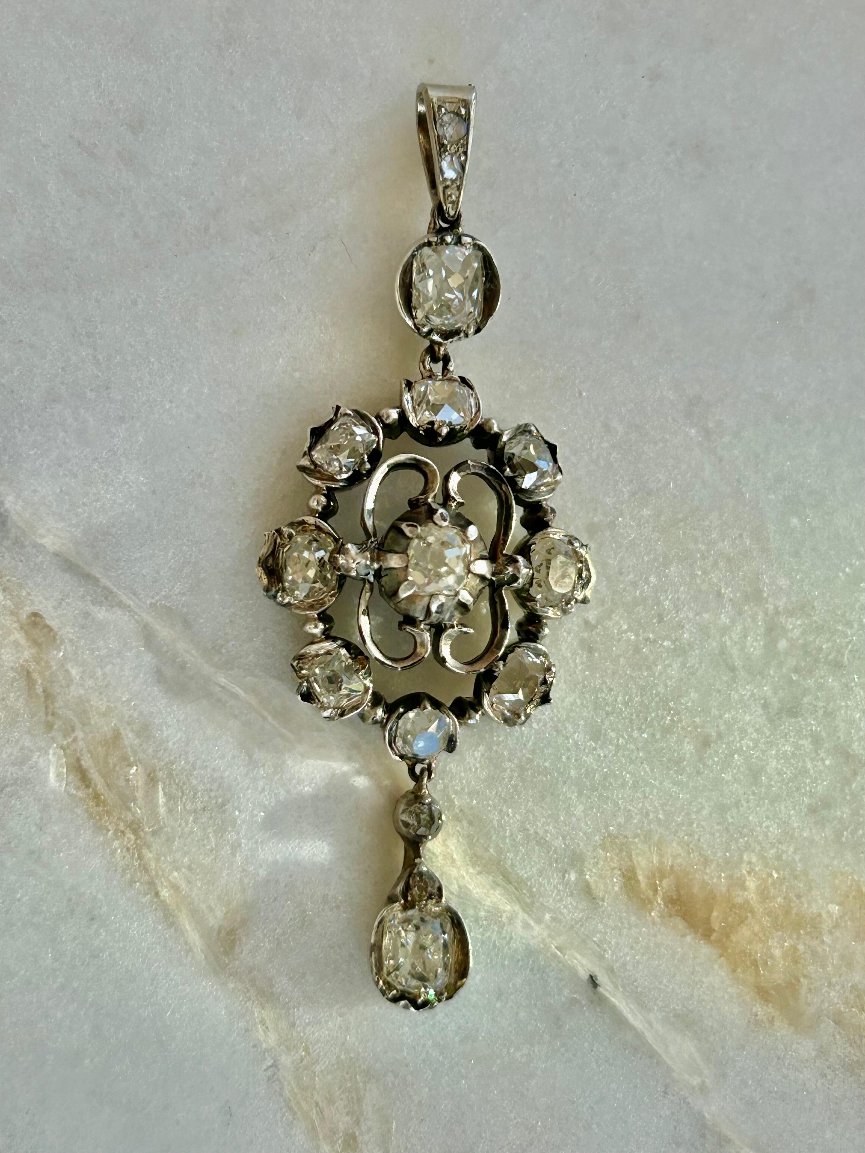 Elegant Georgian Era Pendant:

An Antique Georgian style with Old Mine Cut diamonds cut in a style that predates the typical old mine cut, which were created between the table cut and old mine cut, measuring a delicate 2 inches from top to bottom.