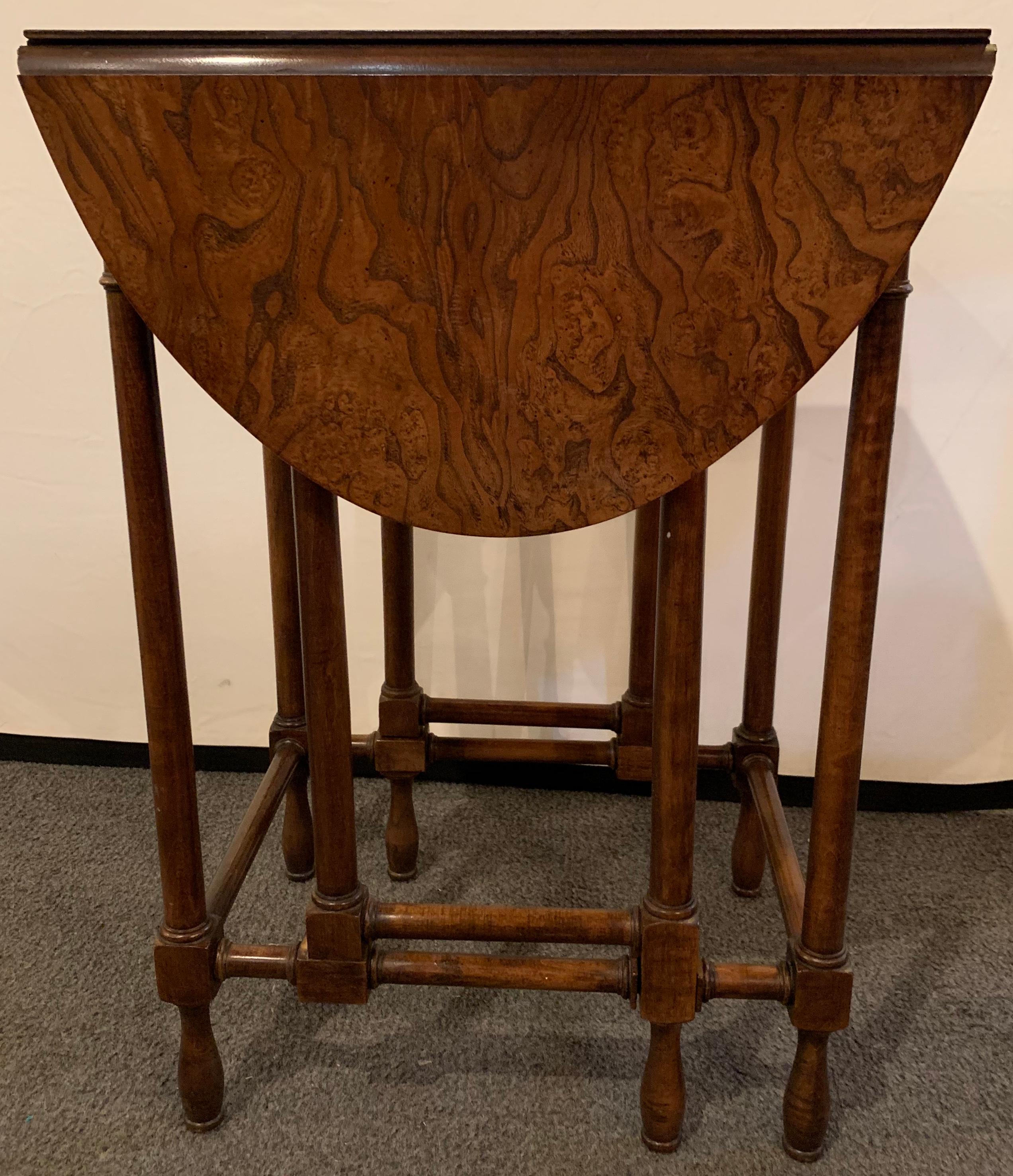 Baker Furniture Company gate leg diminutive end table. A stunning gate leg end or card table in a fine burl wood with flip top sides. This sweet and sleek stylish table opens to sit four for a card game, along side a couch or as a purposeful end