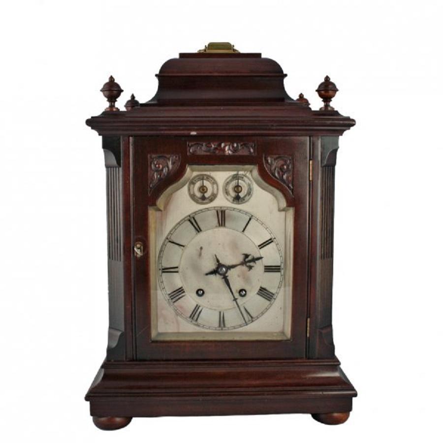 A late 19th century mahogany cased Georgian style bracket clock.

The mahogany case has canted corners, stands on four bun feet, has four turned finial decorations to the top and a hinged brass carrying handle.

The dial is silverised and has