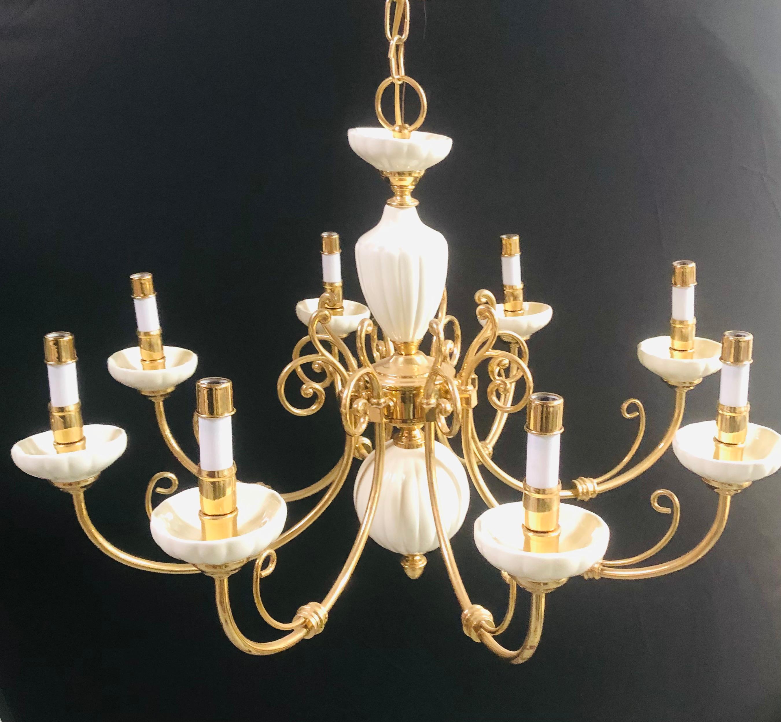 An elegant Georgian style brass and white ceramic eight-arms chandelier. The chandelier features white ceramic bobeches and white urn shaped column with round ball shaped bottom. Elegant fine scrolls defining the style of this chandelier that holds