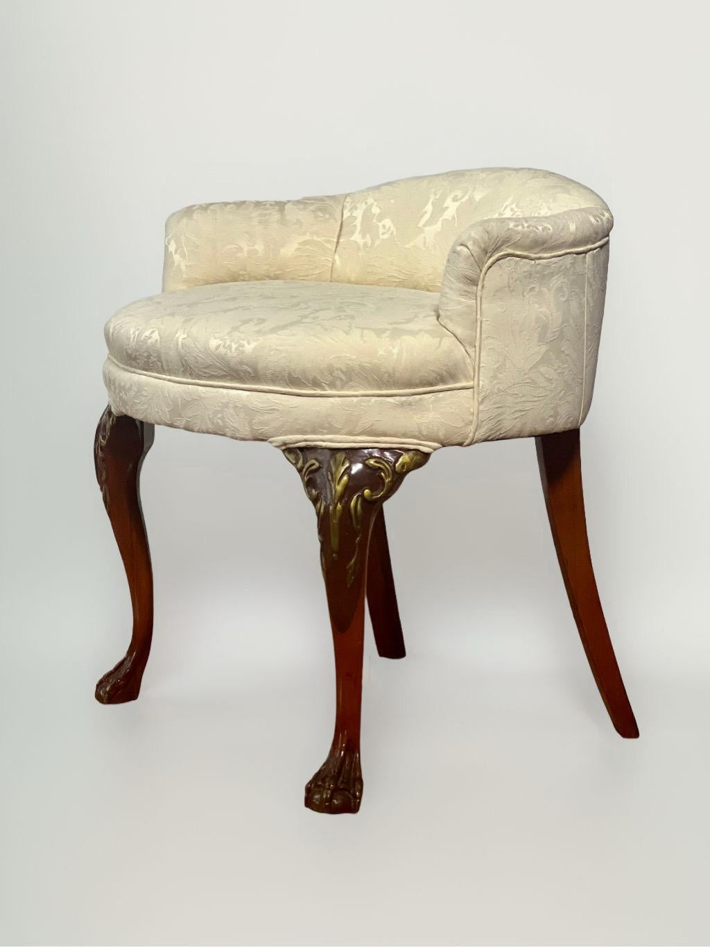 Elegant low back Georgian/Chippendale style vanity chair with carved cabriole legs on ball and claw feet garnished with giltwood accents. Upholstered in a cream damask fabric.