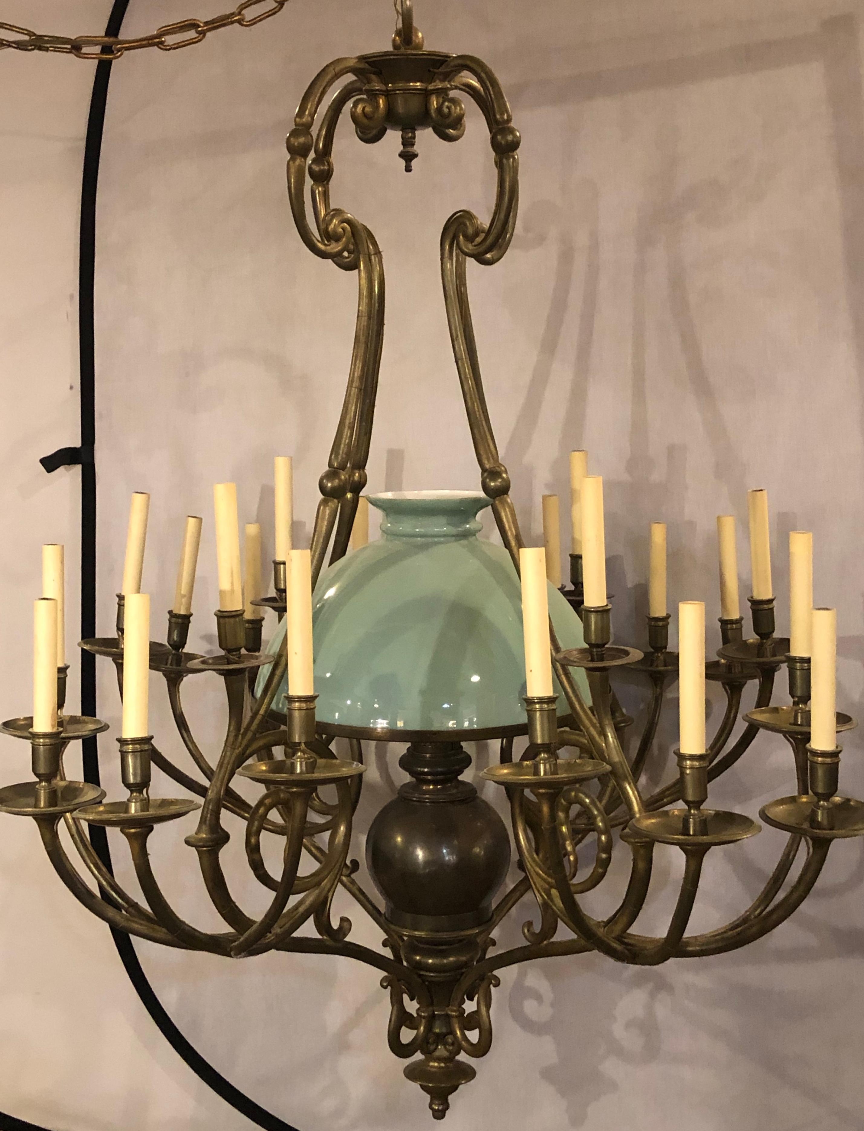 An early 1900s Georgian style chandelier with a globe centre matching chain and canopy. A wonderful bronze form twenty one light chandelier having four arms sets of five lights each with a centre green globe taking one large bulb. The whole recently