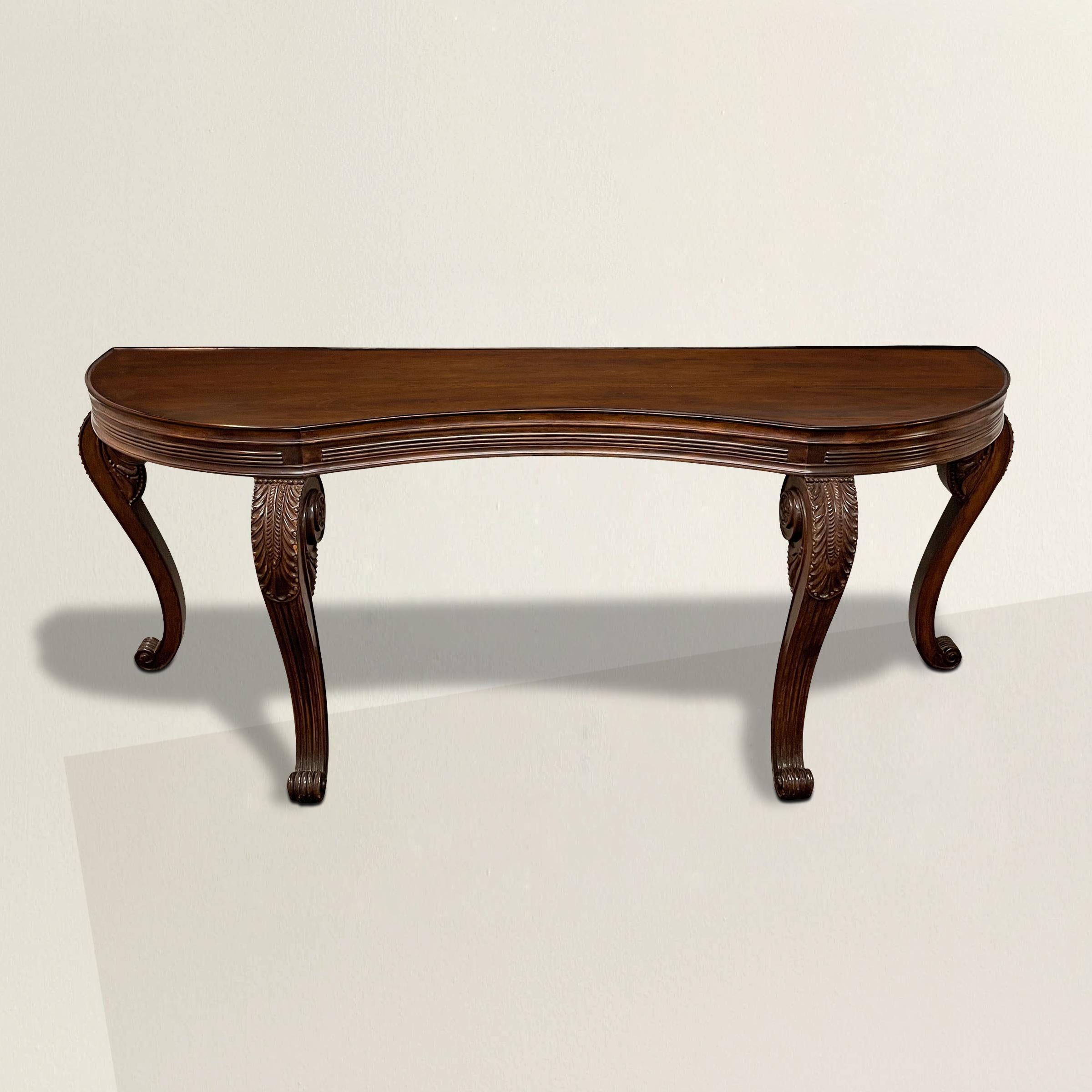 A remarkable massive 20th century Georgian-style walnut console table with a serpentine front, a reeded apron, and four cabriole legs with carved acanthus leaves details and scrolled feet. Perfect as a console table or sideboard in your dining room.