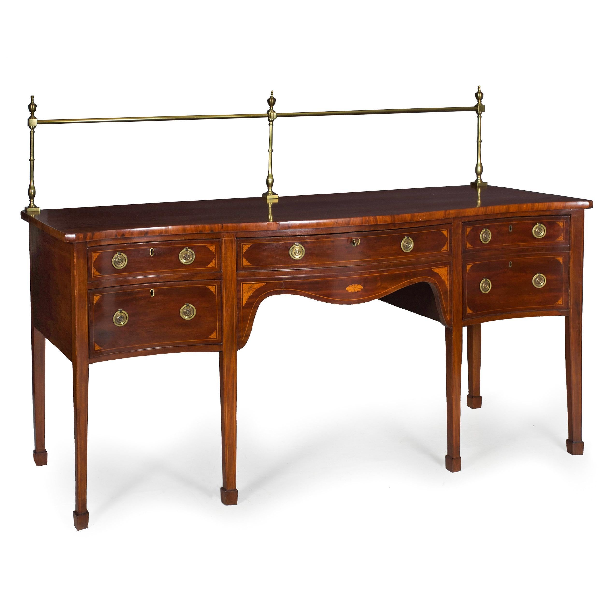 A good 19th century sideboard in the George III style with rich and beautifully patinated mahogany veneers throughout augmented with lovely inlaid satinwood spandrels and panels, it features a delicate serpentine form with a matching serpentine