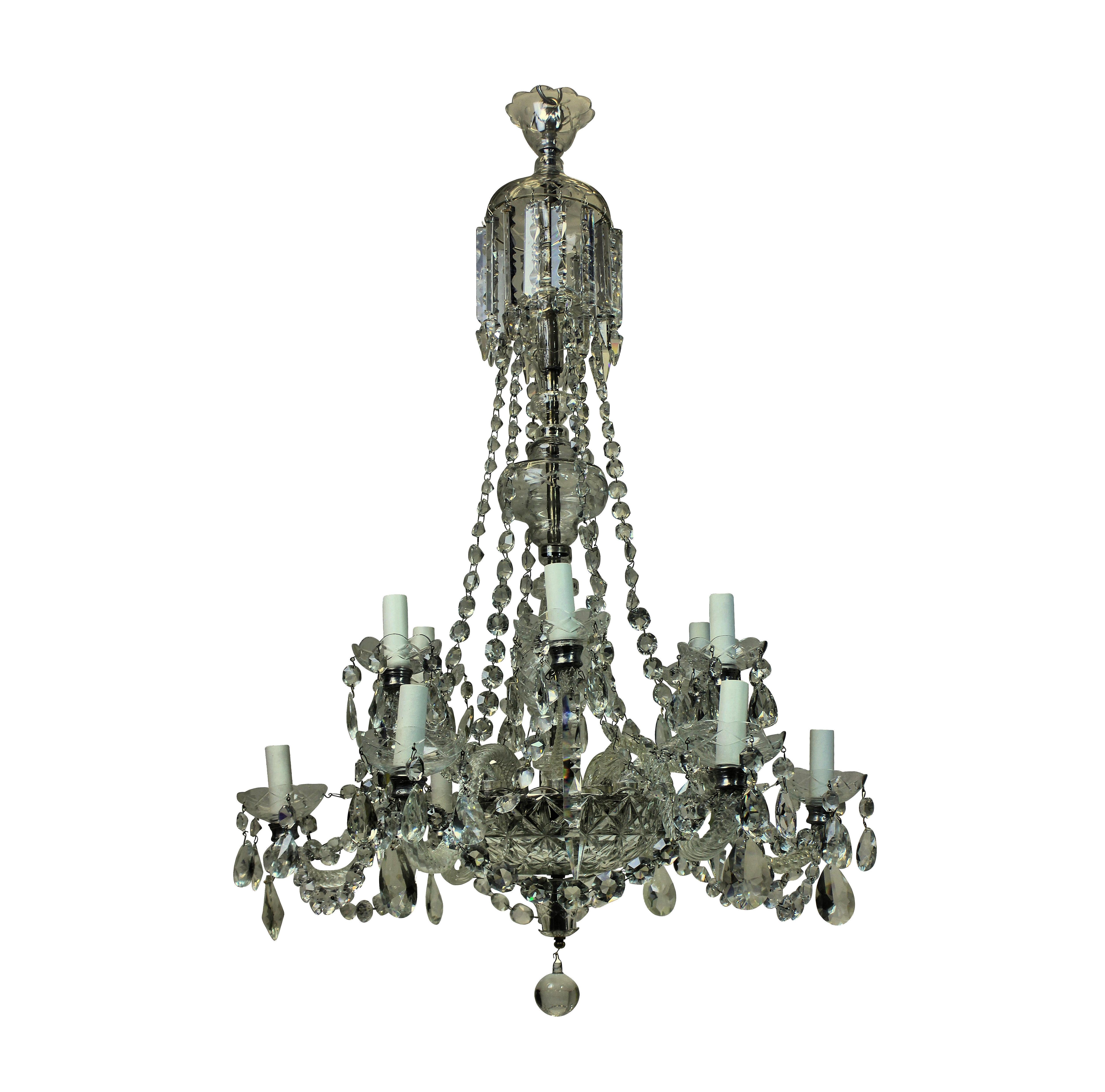 An English traditional cut-glass chandelier with up-swept and down-swept arms. Hung throughout with chains, swags and pendants.
  