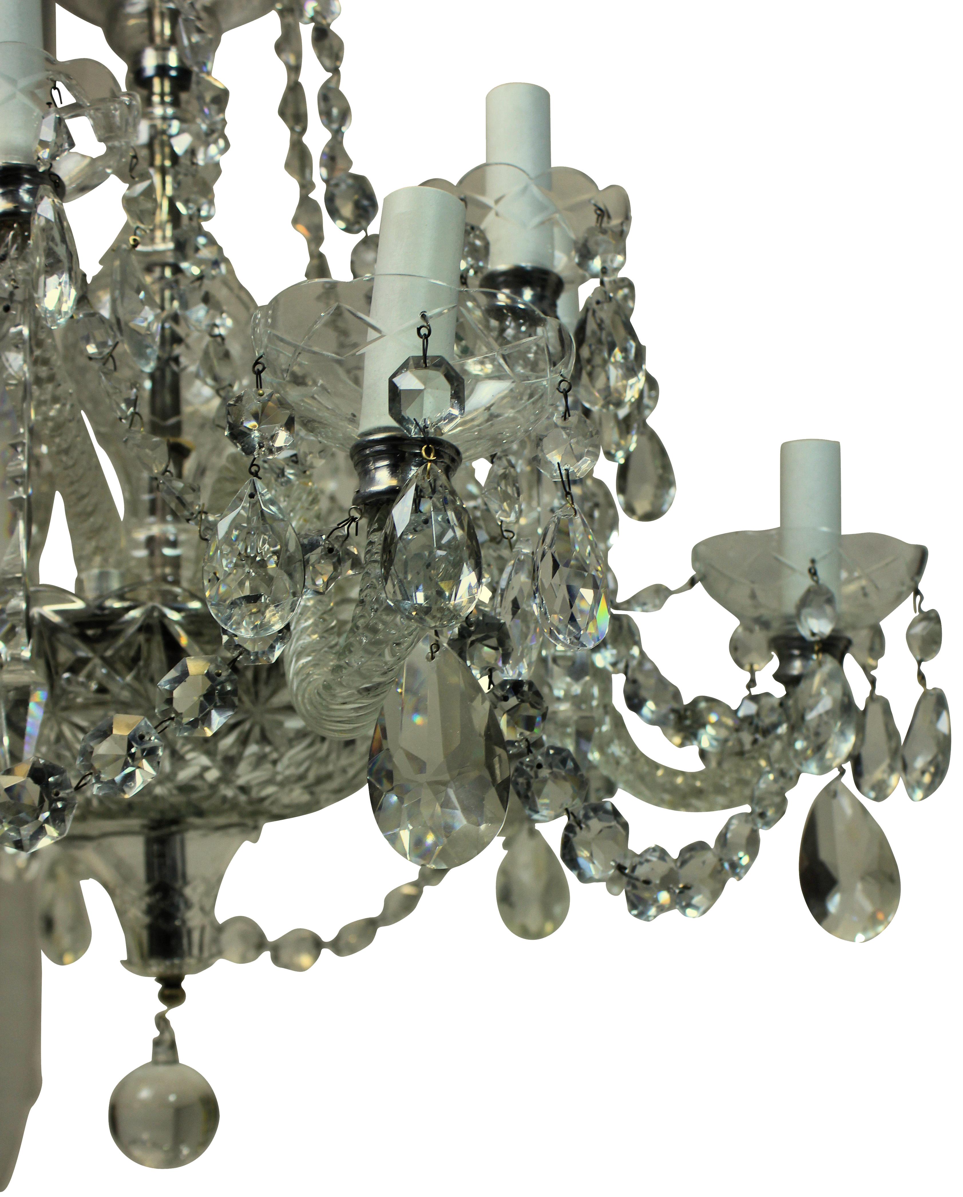 An English traditional cut-glass chandelier with up-swept and down-swept arms. Hung throughout with chains, swags and pendants.
 