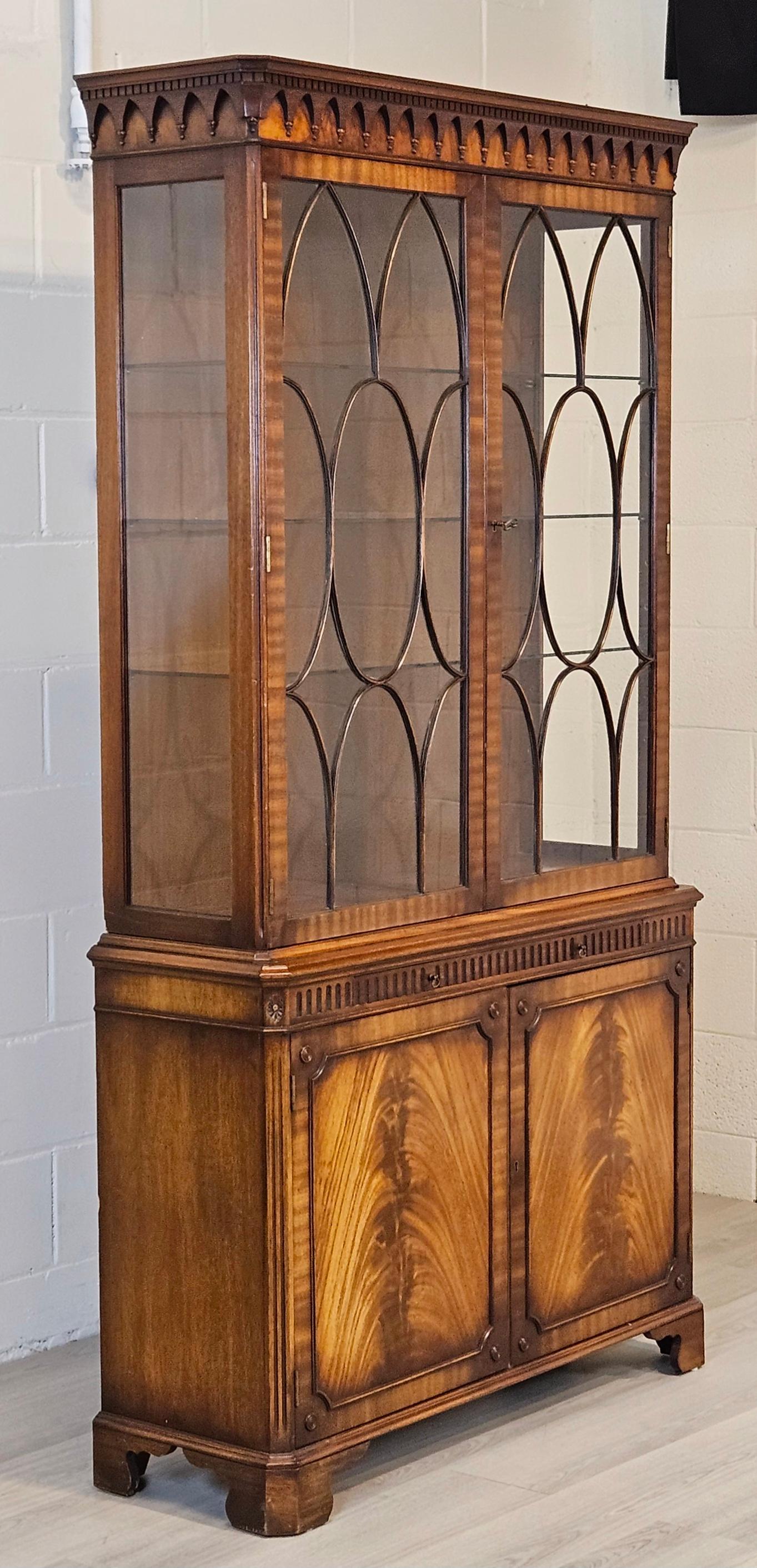 A wonderful Traditional English Display Bookcase in Georgian Style crafted in Mahogany.  The cabinet has two doors framed in mahogany with individual hand cut astragal glazed glass panel and glass side panels and adjustable glass shelved. 
The way