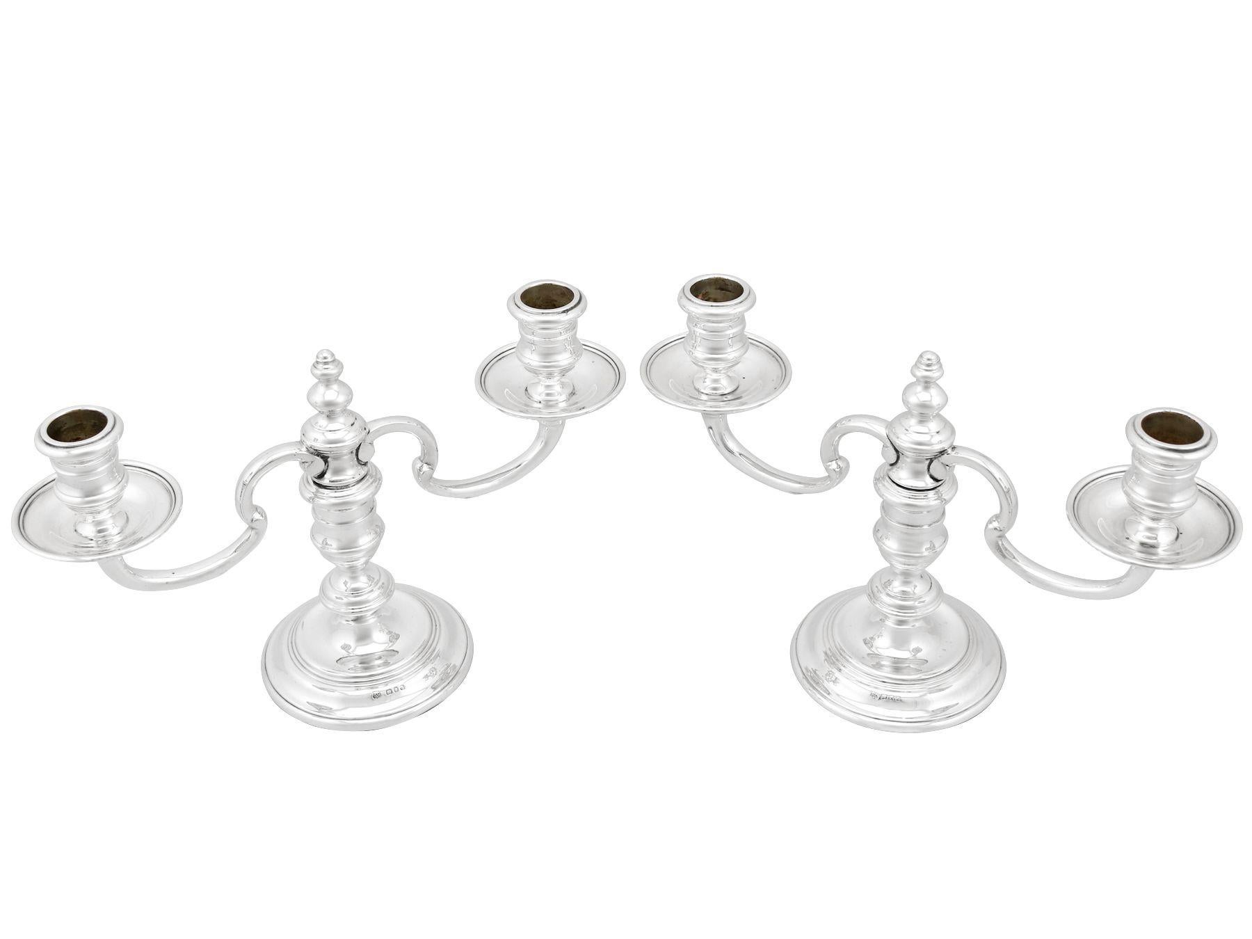 A fine pair of vintage Elizabeth II English sterling silver two-light candelabra in the George I style; an addition to our ornamental silverware collection.

These fine vintage Elizabeth II sterling silver candelabra have a plain circular form, in