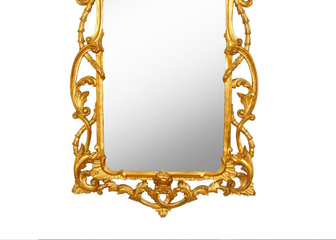 Georgian style giltwood carved mirror with dramatic scroll and leaf details.