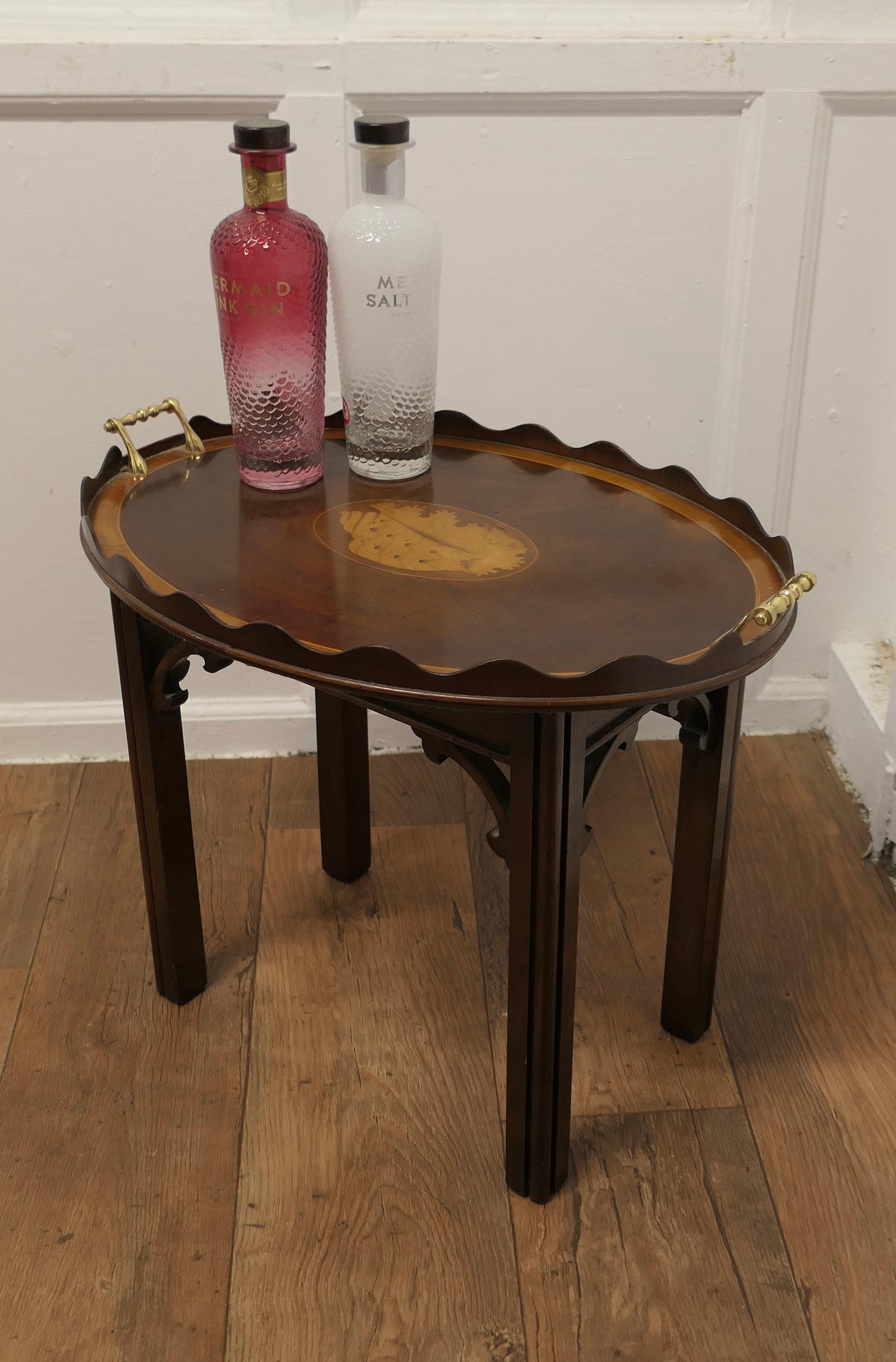 Georgian Style Inlaid Butlers Tray on Stand

This is a superb quality piece, the tray top fits on to the legs forming a neat drinks table 
The tray is oval and decorated in the Sheraton style with a large conch shell at the centre it has a raised