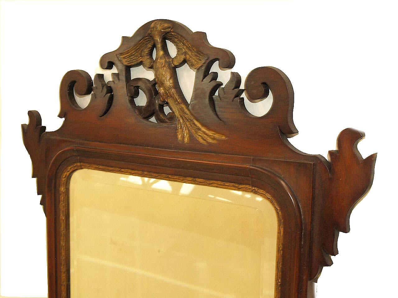 Miroir marqueté de style géorgien dont la crête présente un phénix doré, le miroir biseauté d'origine entouré de moulures dorées, la partie inférieure avec une conque marquetée.