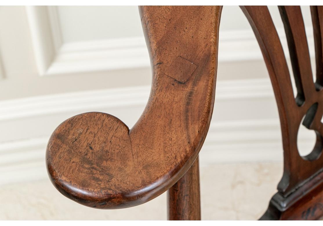 With classic Georgian curved openwork splats. The carved crest rail ending in scrolled arms, with three turned supports. The seat rail with shaped ends raised on a front cabriole leg with wide knee and two back square and cylindrical legs with pad
