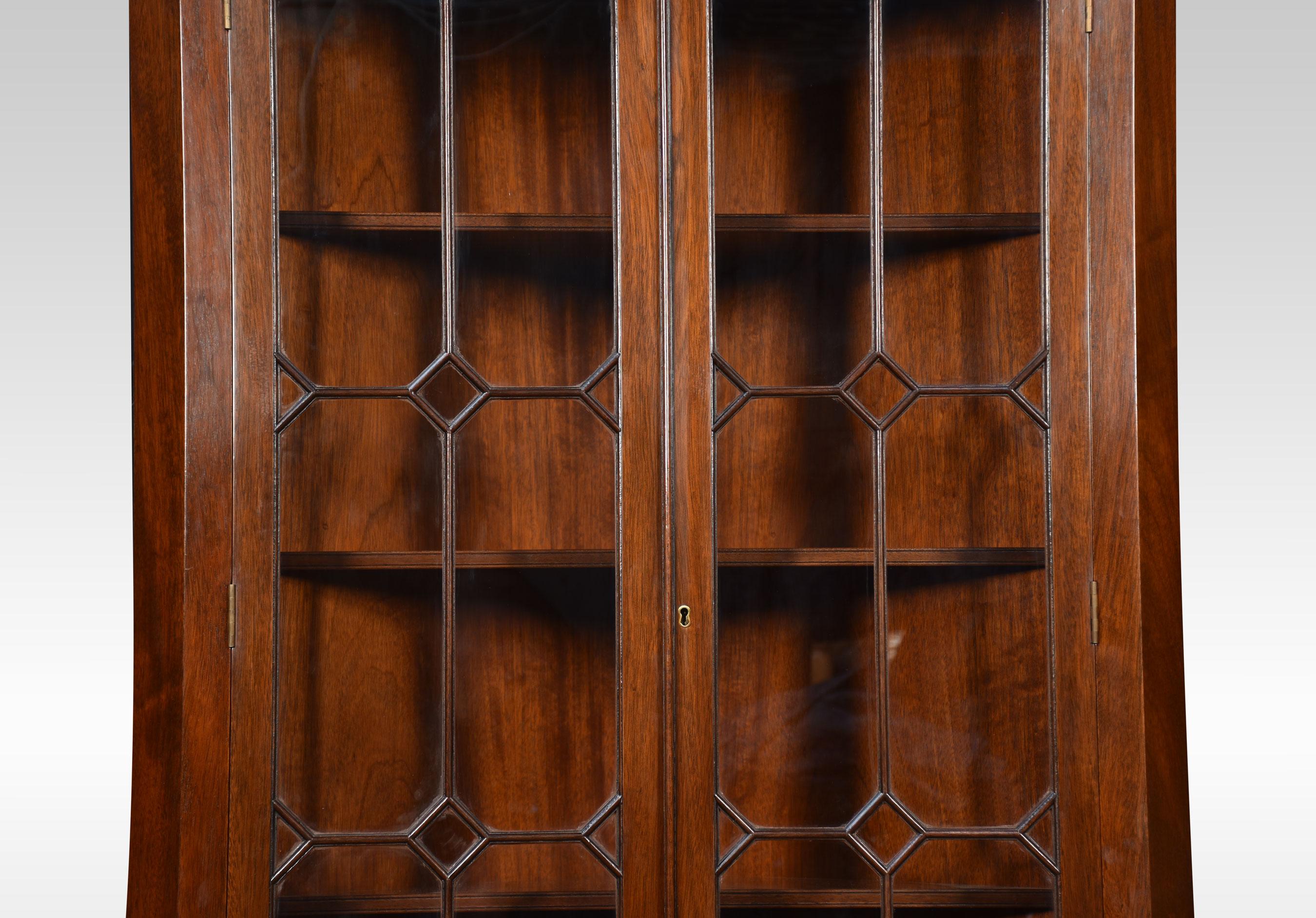 Mahogany standing corner cupboard the molded top above a pair of glazed beaded doors opening reveal shelved interior. The base fitted with a pair of well-figured mahogany paneled doors opening to reveal a single fixed shelf. All raised up on bracket