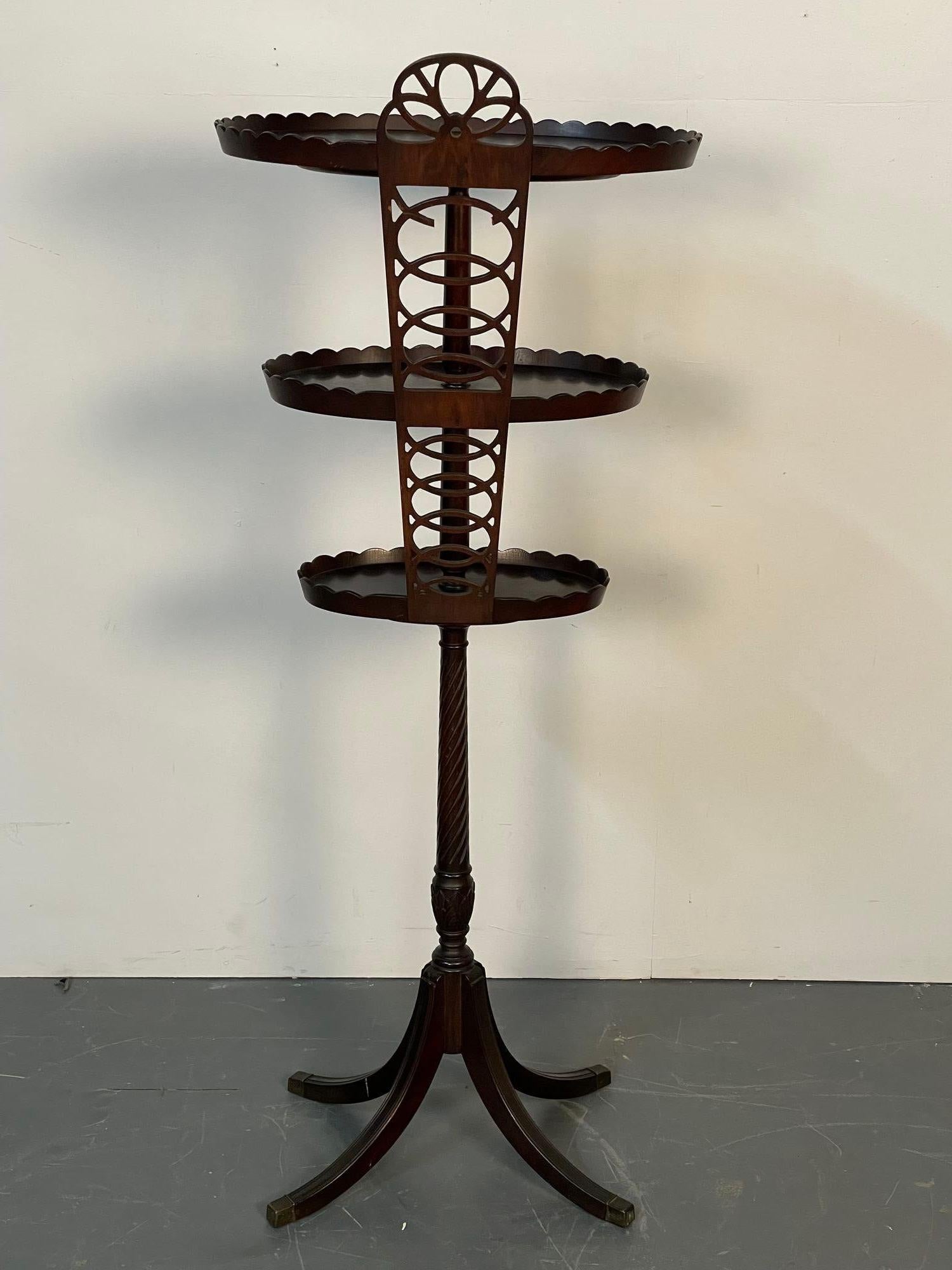 Georgian Style Mahogany tri-shelf desert stand / dining room accent décor
A stunning desert or plant stand in mahogany having four sprayed legs leading to center column support having three galleried shelves terminating in a full pierced back. A