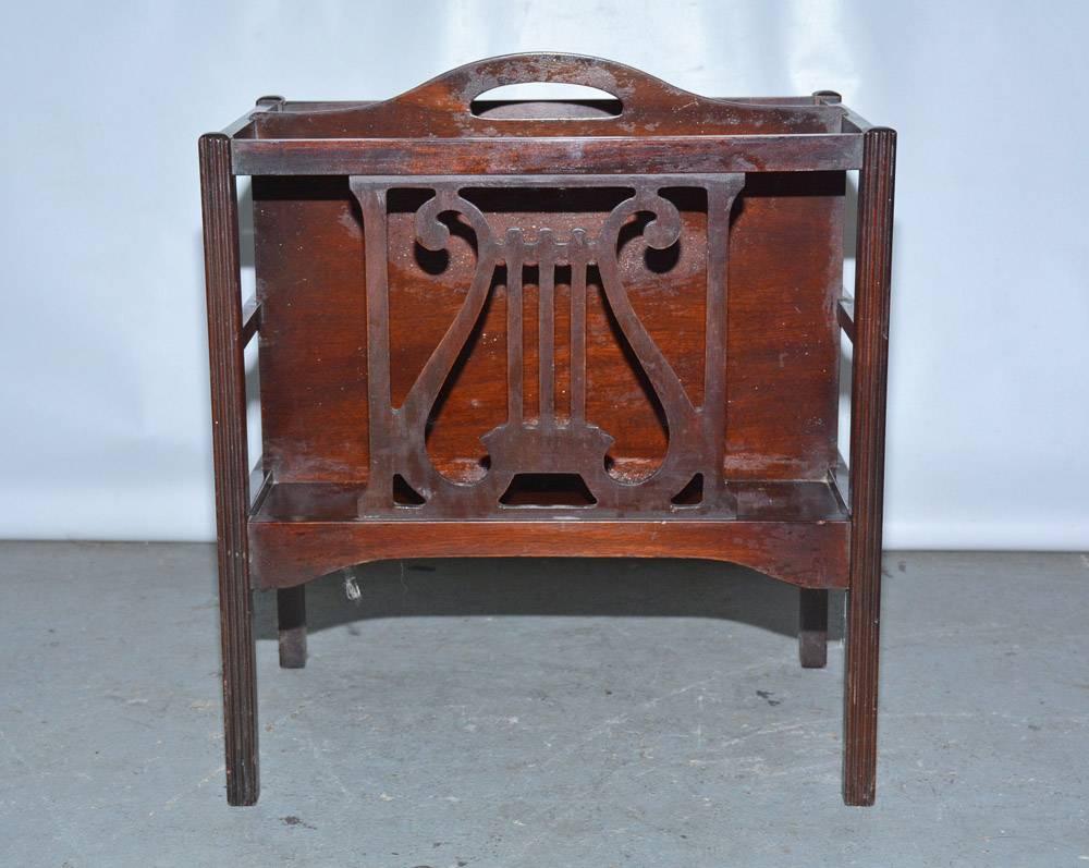 The Georgian style two-section magazine rack or canterbury is made of mahogany veneer. The sides have a lyre design, there is a handle, and possibly the unit was used for sheet music.