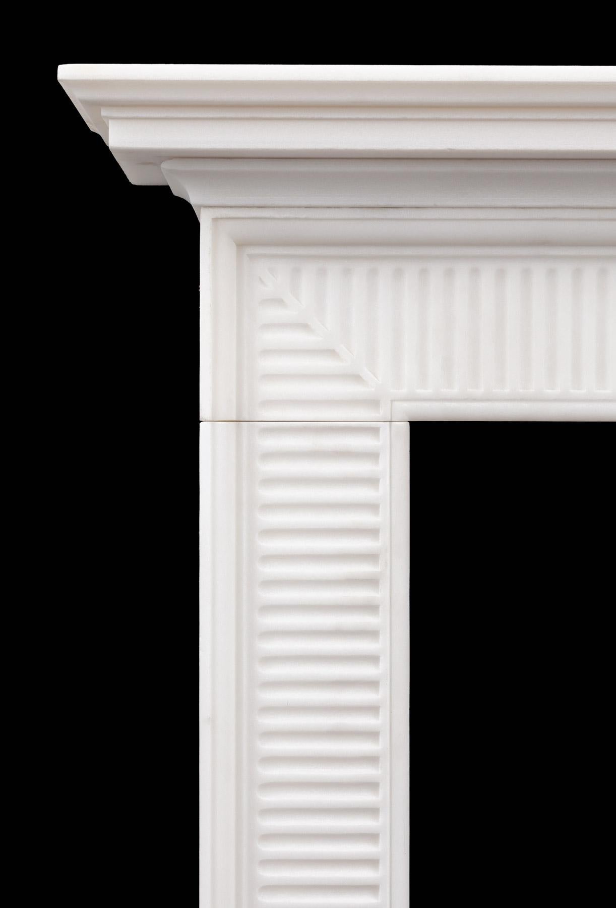 A pure white marble fireplace of refined late Georgian design.
The wide molded frame is carved with finger flutes that come to a mitre in each corner, this with cornice shelf resting on top.

The Wilton mantelpiece is based on an 18th century