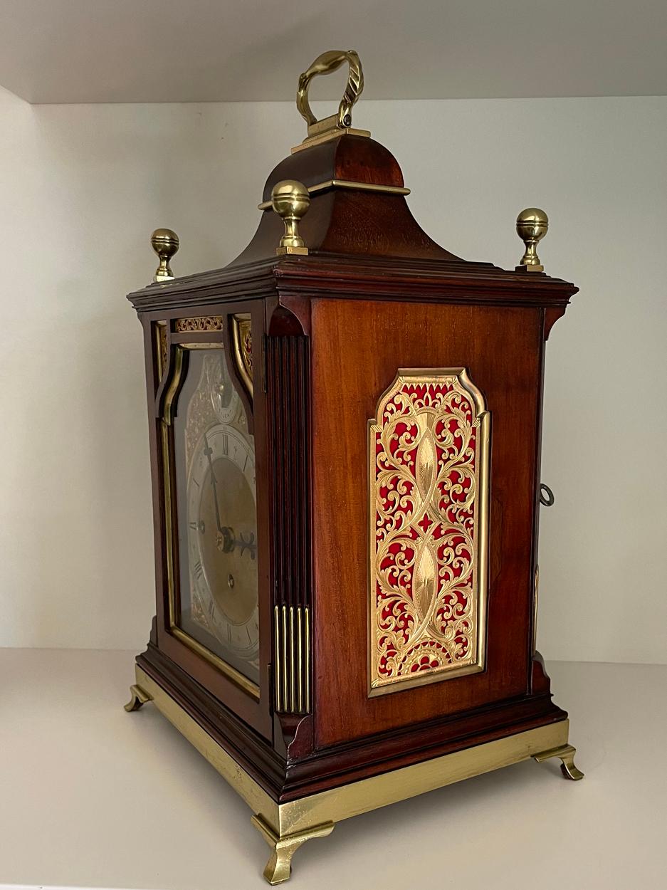 A stunning 19th century Victorian mahogany cased Georgian style clock of compact proportions. The lantern topped case with decorative brass sound frets to the sides backed with red silk, brass vertical inserts to the front pillars and inserts to the