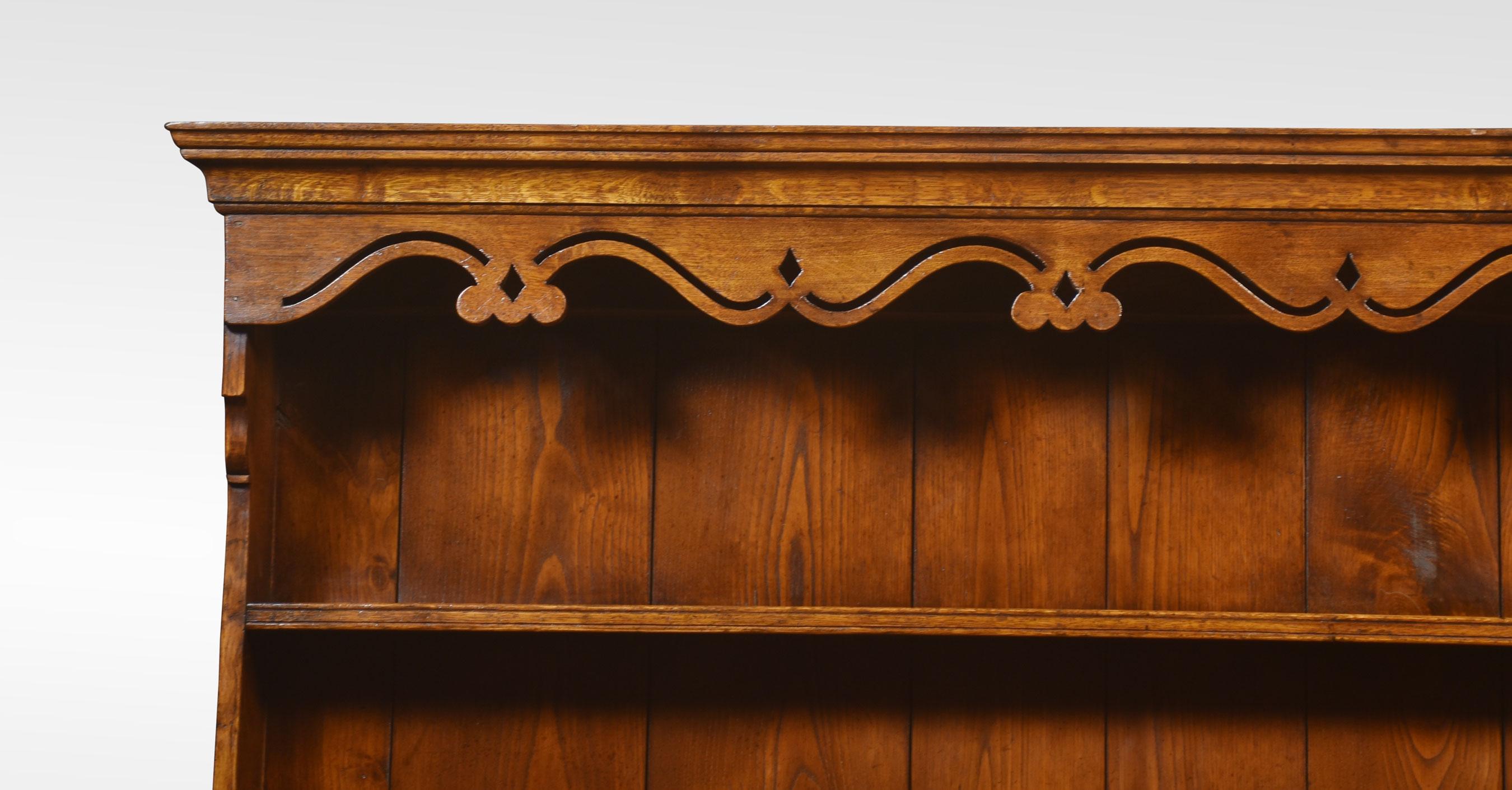 Georgian style oak dresser, the top plate rack top with a wavy apron, and two shelves above an assortment of small drawers with brass knob handles. over a base with large rectangular cross banded top and three frieze drawers and swan neck handles