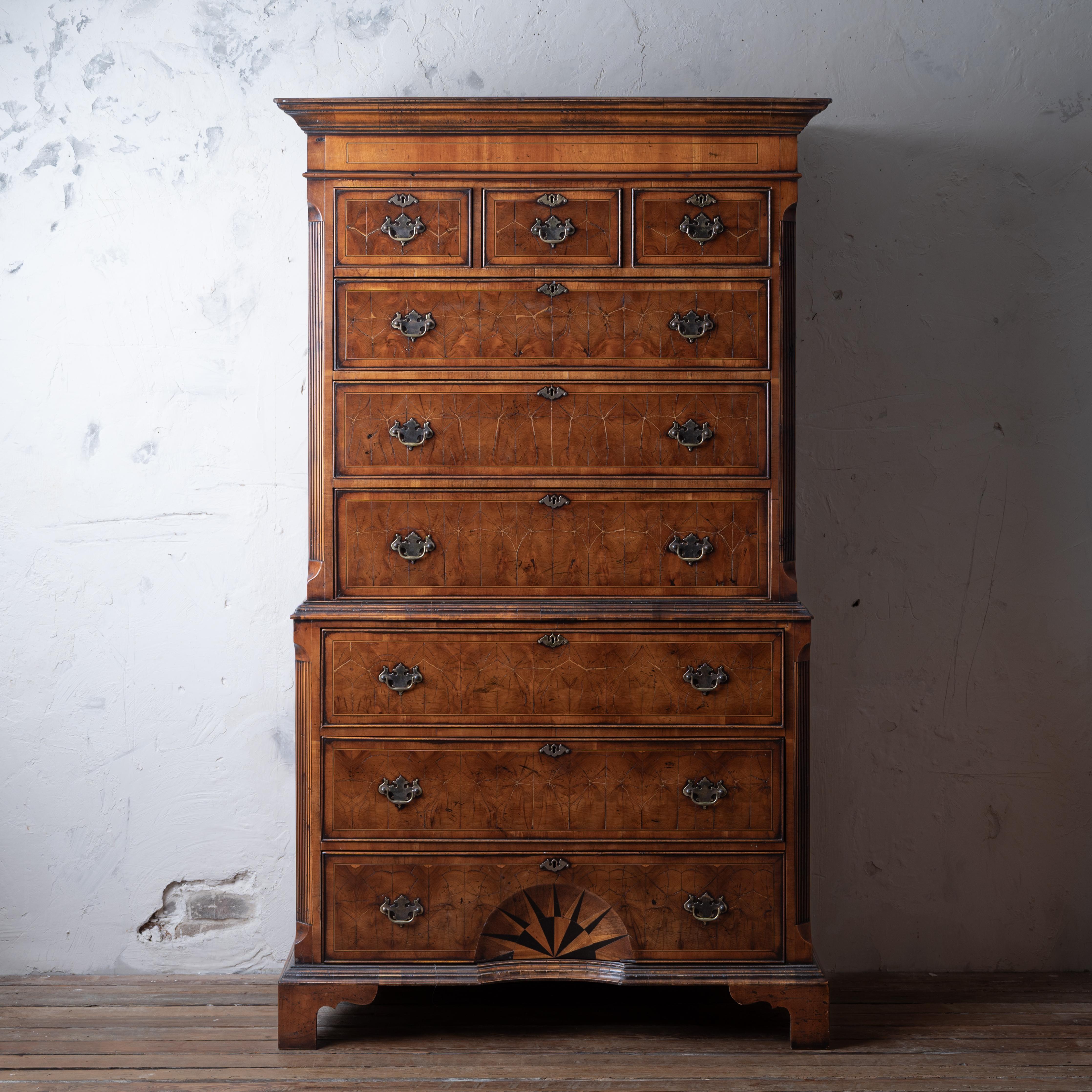 A Georgian style yew wood oyster veneer tallboy chest on chest, 20th century composed of new and old elements.

44 ½ inches base width (44 ¾ inches at cornice) by 23 ½ inches deep by 76 ½ inches tall

