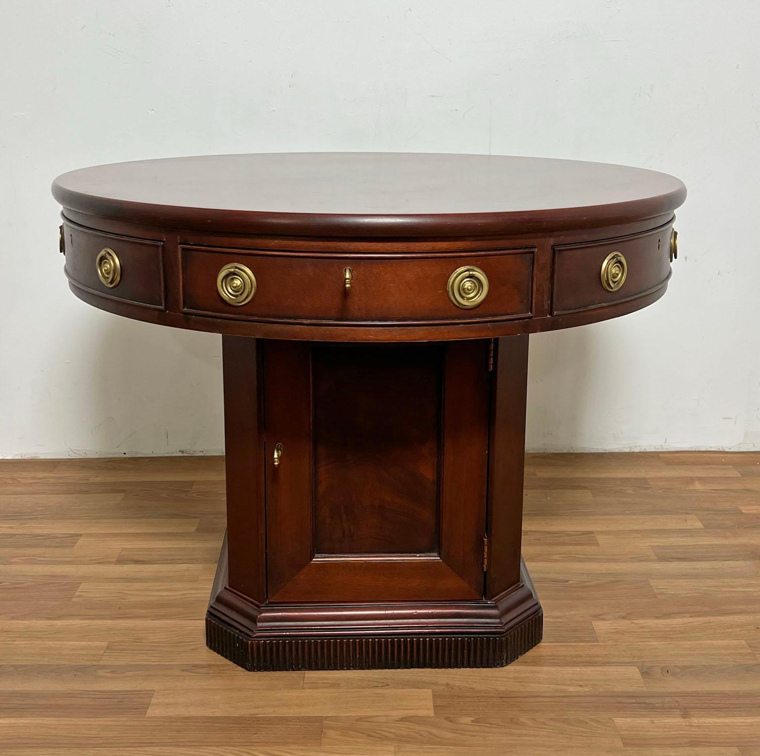 A Georgian style mahogany rent table by Ralph Lauren, ca. early 1990s. Features a banding of drawers along the edge top and a locking cupboard beneath with plenty of room for the landlord’s bags of gold!
