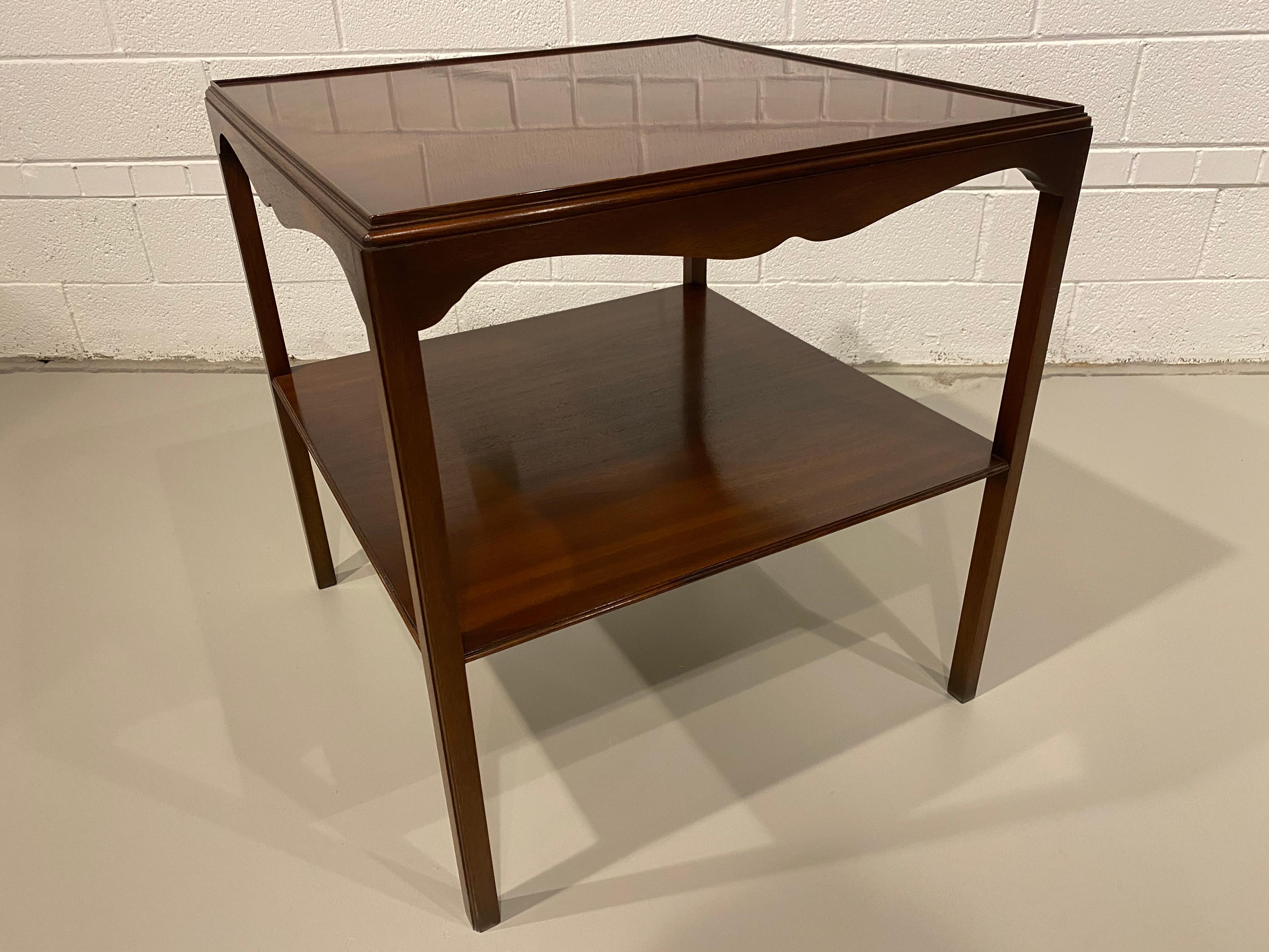 A large square Georgian style English made side table by Bevan Funnel. This lovely table has a generous size and a simple elegance to the polished mahogany. There is a lower shelf that adds to the style and utility of this item.
  