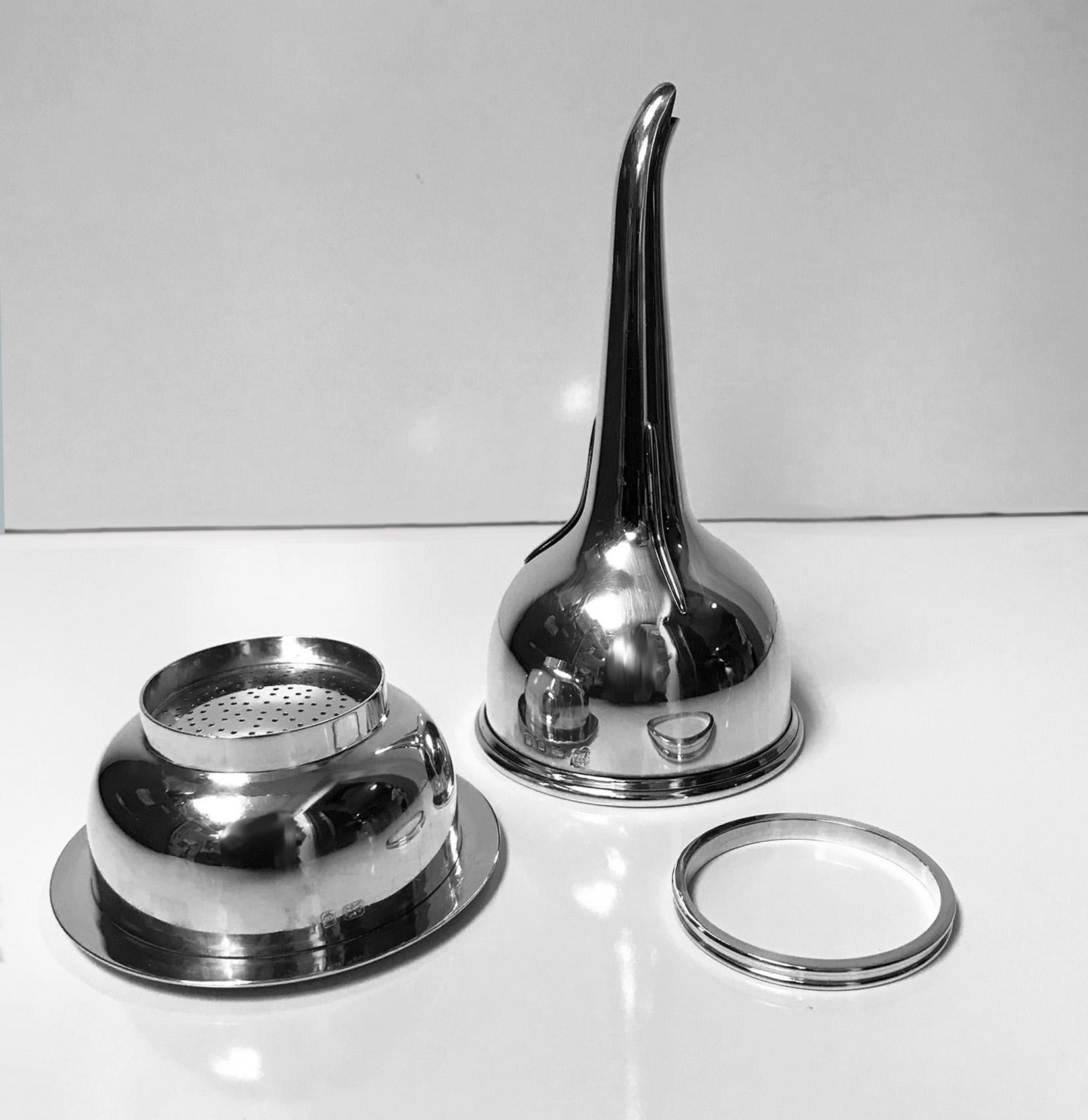 Georgian style Silver Wine Funnel, London 1975 Snow and Ashworth. The Funnel of typical form, the base with moulded surround, plain body, strap work funnel, plain clip, interior detachable muslin ring. Marked on body and strainer. Height: 5.75