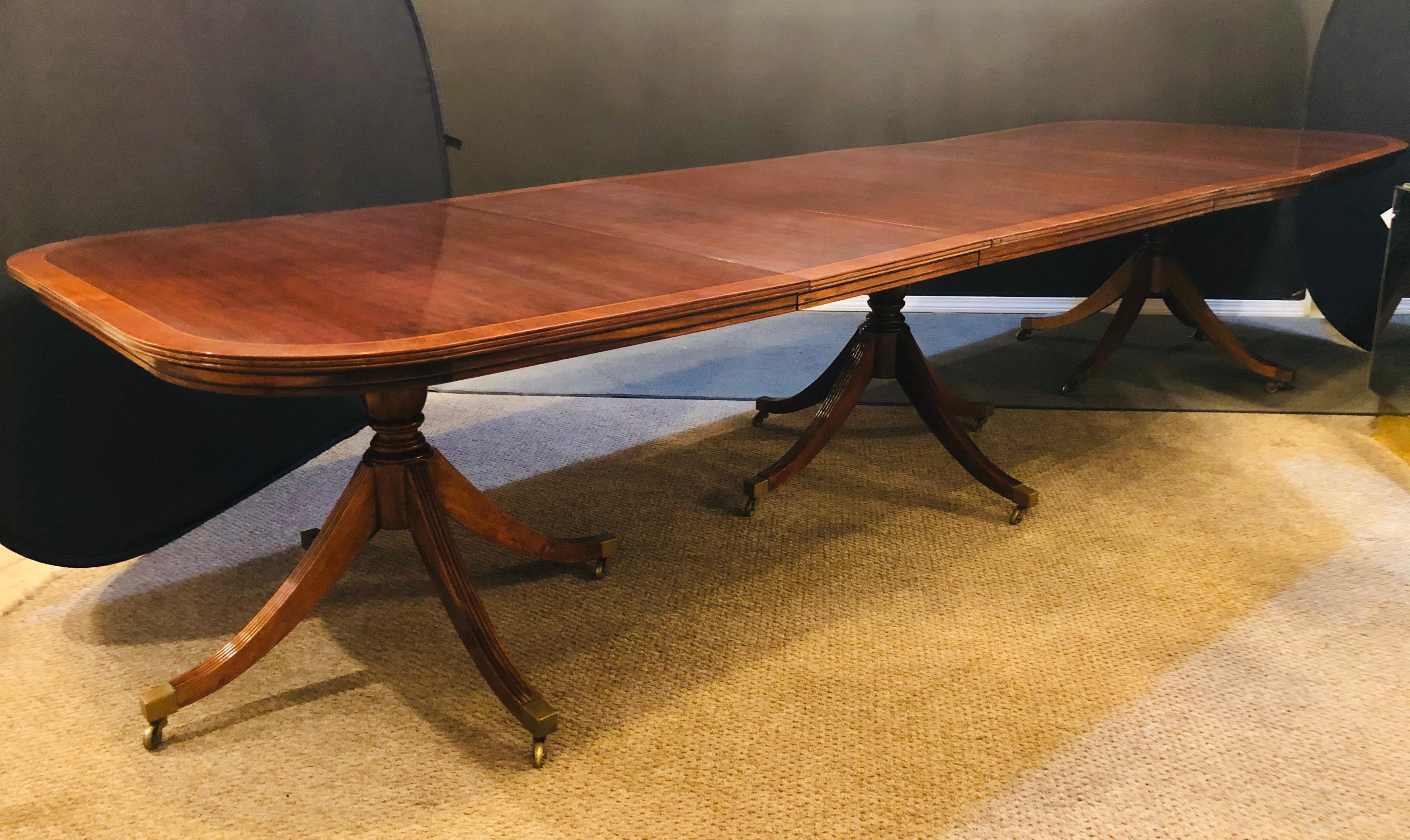 Georgian Style Triple Pedestal Dining Room Table. Flame Mahogany & Satinwood Banded just in time for the holidays. This finely constructed and sturdy dining table is simply stunning depicting old world charm and formal dining at its best. Each of