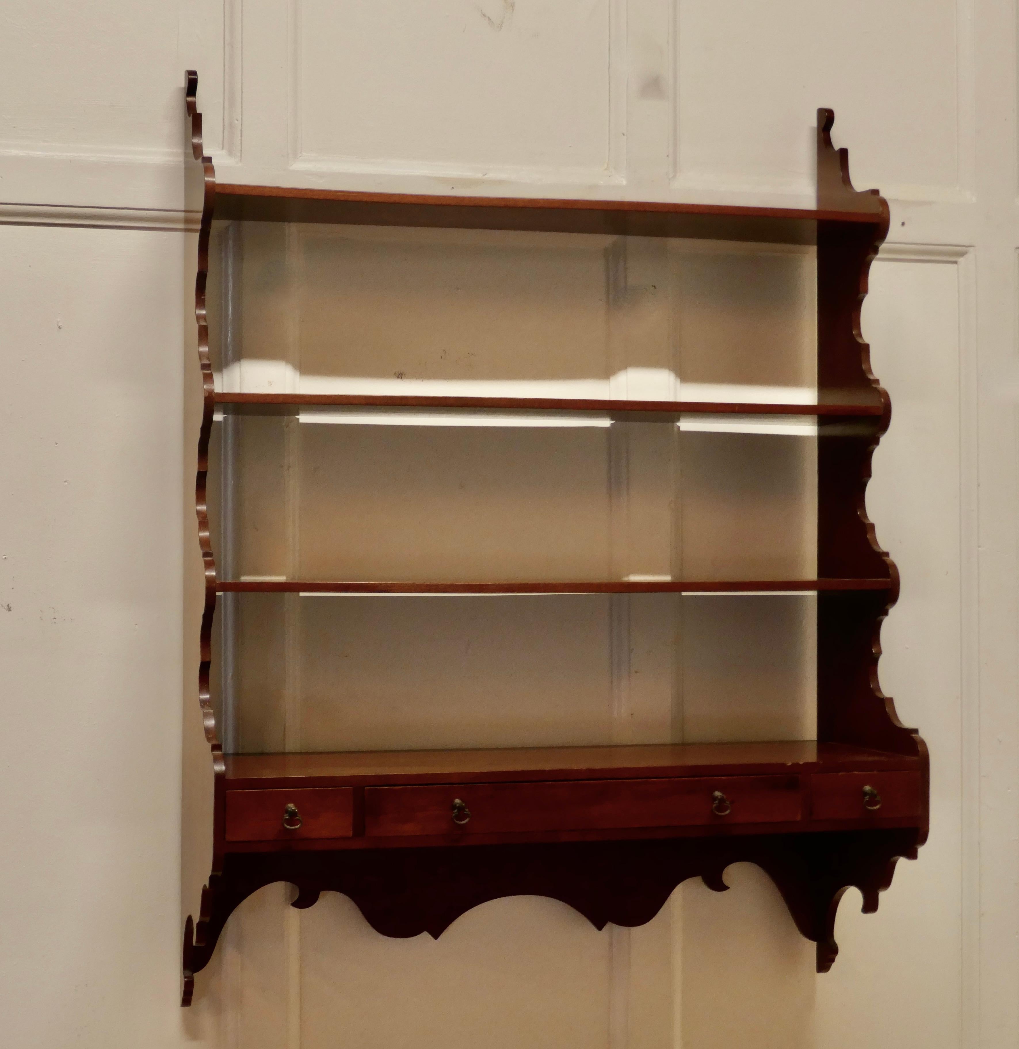Georgian style wall hanging shelf with drawers

This charming is a little shelf unit, the shelf has scalloped waterfall sides and apron, there are 3 shelves and at the bottom there are 3 small drawers to the front. 
The shelf is in good condition