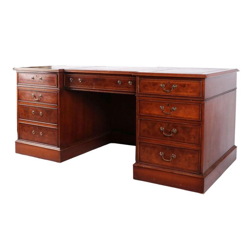 A Georgian style three section walnut partners desk, with one center drawer and four drawers on each side. The top is inset with three sections of brown leather and gold trim. Opening to apron of kneehole measures 24 1/4