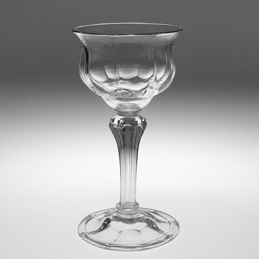 Encabezamiento : Bombonera georgiana con pedestal c1750
Periodo :  Jorge II
Origen : Inglaterra
Color : Transparente
Cuenco : Conopial moldeado radial con borde evertido
Vástago : Vástago de pedestal hueco con ocho lados y rombos hasta el hombro
Pie