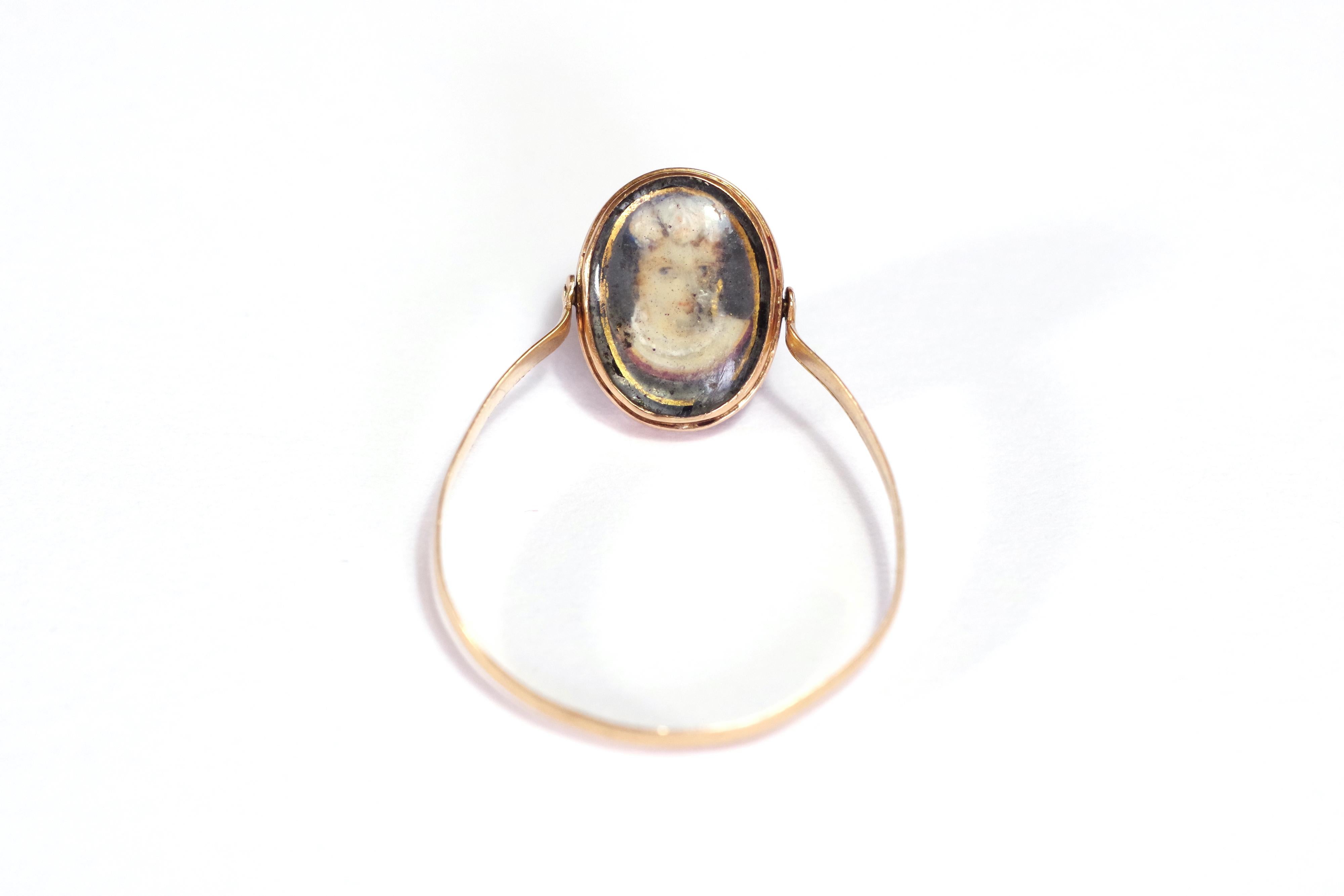 Georgian portrait swivel ring in 18 karat yellow gold. Antique ring with pivoting bezel, decorated with pansies and a portrait of a young woman. The miniatures are painted on mother-of-pearl and circled in black and gold. Swivel sentiment ring from