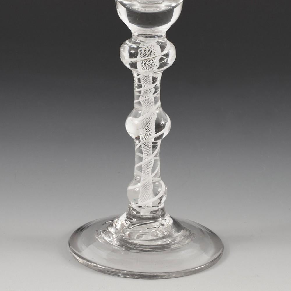 Heading : An 18th Century Triple Knop Opaque Twist Wine Glass
Period : George II - George III
Origin : England
Colour : Clear, good grey tome
Bowl : Bell shaped with thickened base, excellent pucella marks
Stem : Graduated flattened ball knop above