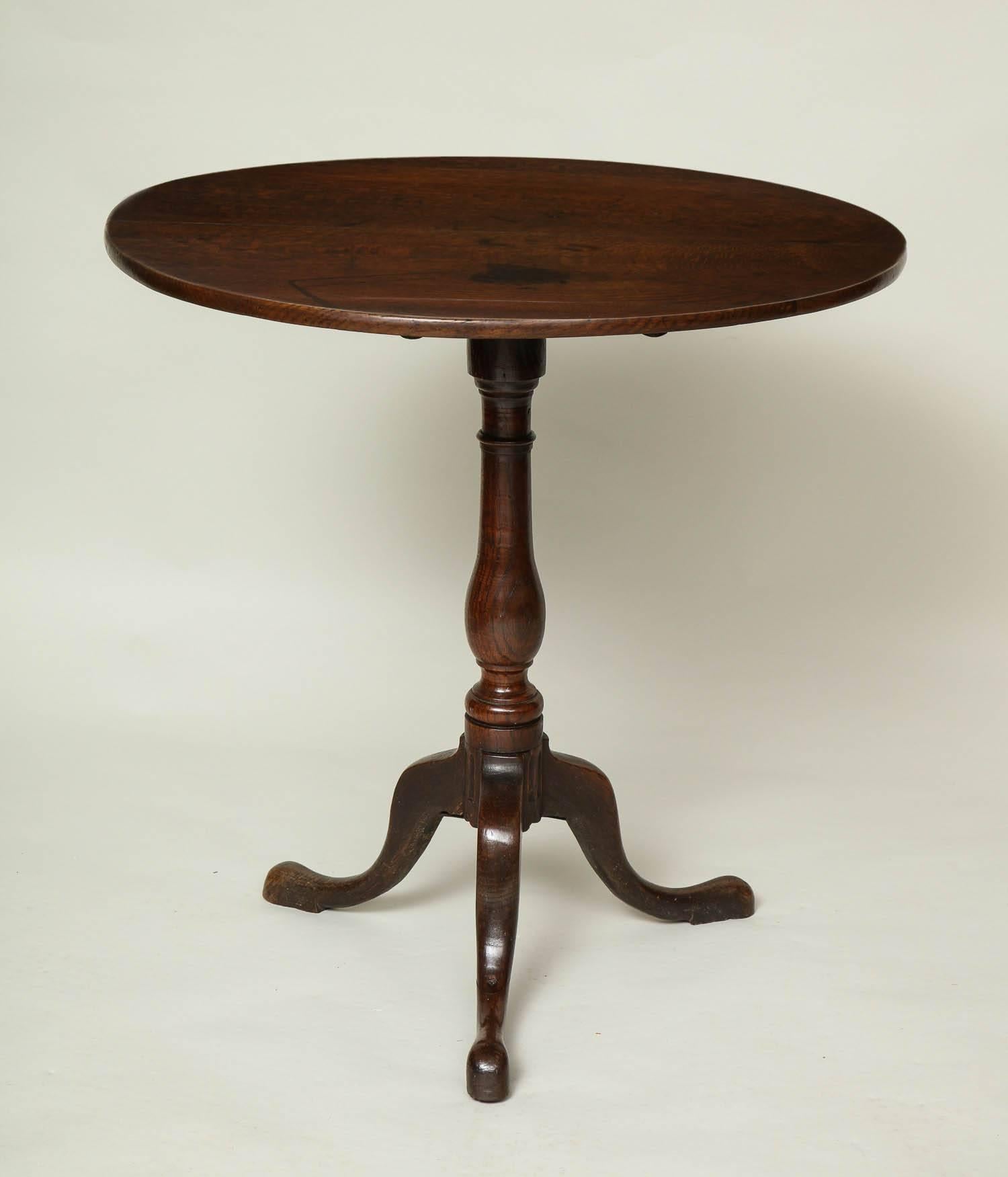 Good 18th century English oak circular table having a nicely patinated top over vase turned base with fluting to the base and standing on cabriole legs ending in slipper feet, England, circa 1770.
