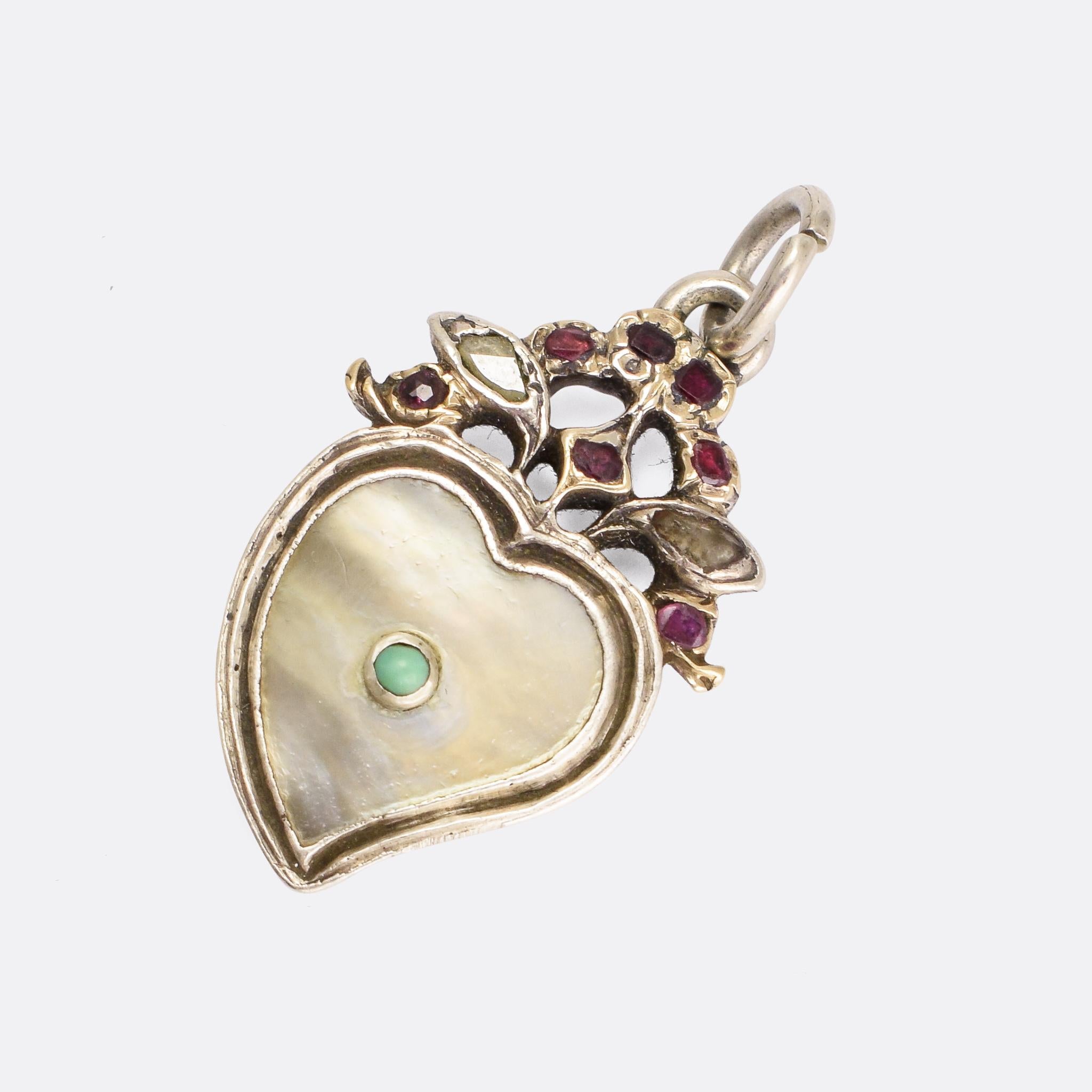 A sweet 18th Century Witches Heart Pendant dating from circa 1780. A turquoise cabochon sits within heart-shaped mother of pearl centrepiece, while the frame above is set with diamond and garnet Giardinetti motifs. The execution is excellent, in