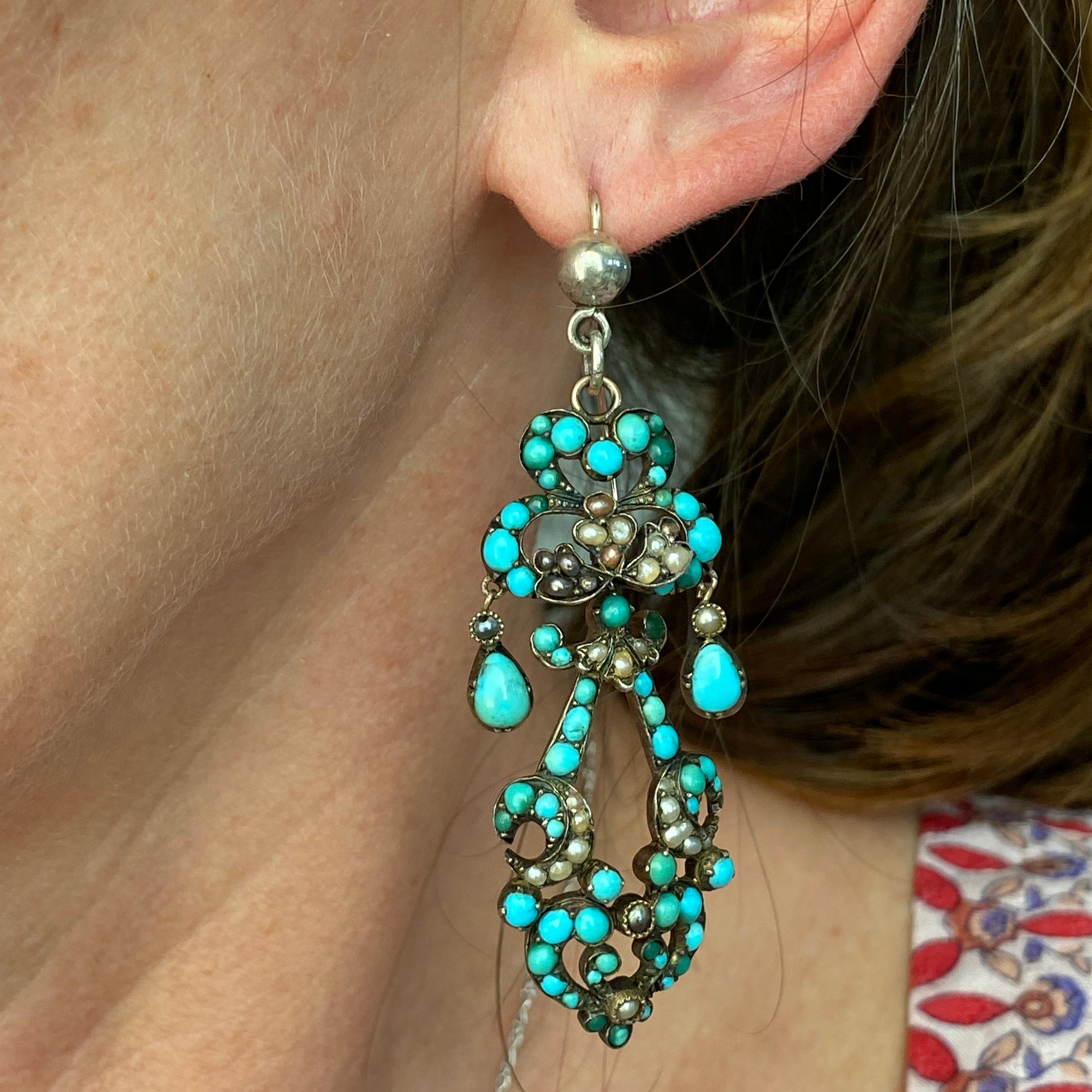 Details:
Stunning Georgian turquoise, seed pearl and silver chandelier earrings. They are articulated, and have lots of movement. The turquoise has a lovely bright blue color. The ear wires were replaced at some time along the way. One of the tear