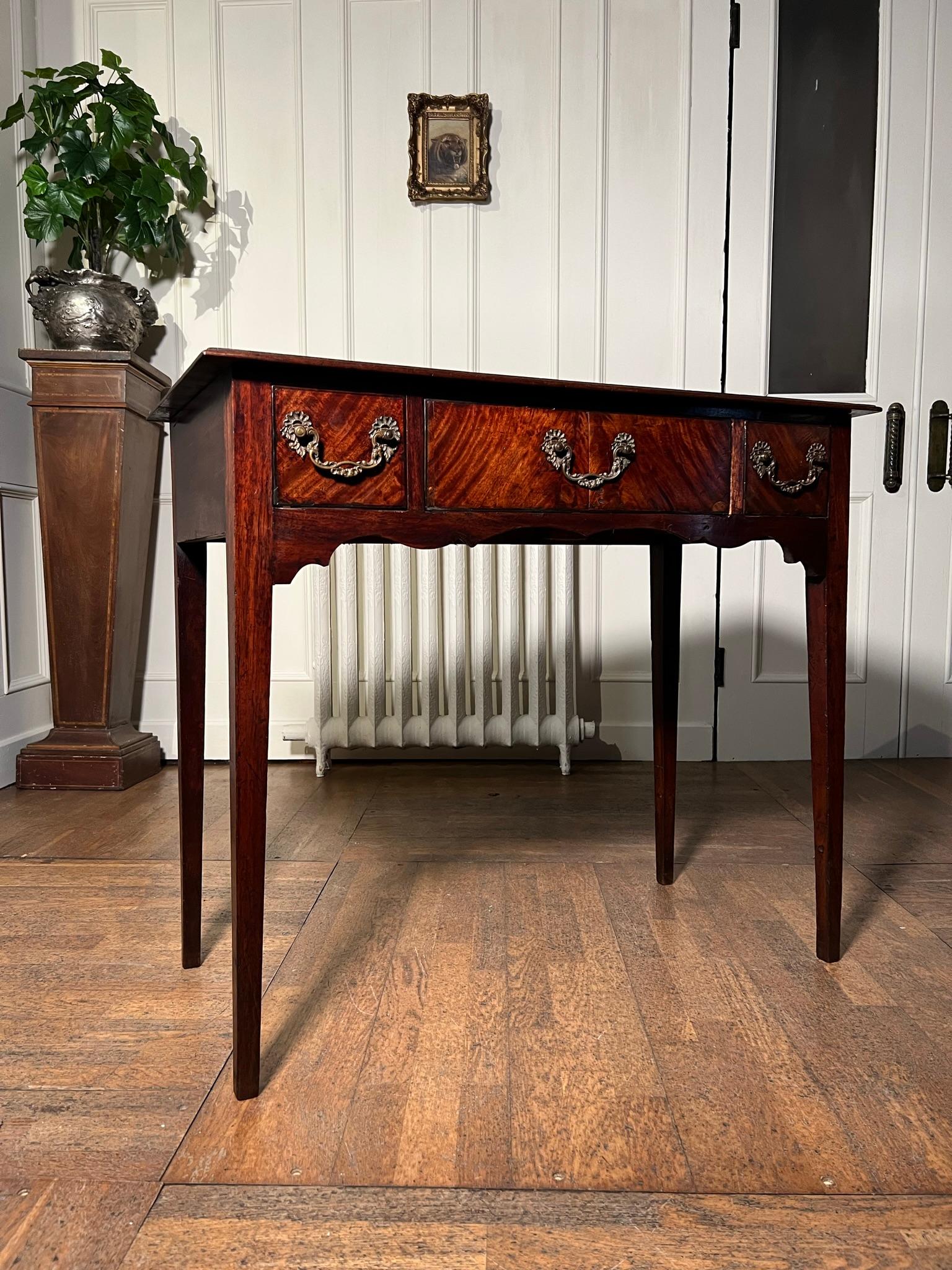 18th century walnut veneered side table on slender tapering legs.

Scroll front apron below 3 finely crossbanded drawers with Chippendale style pulls.

Measurements: 80cm h x 92cm w x 45cm d

(measurements are approximate and are taken at the