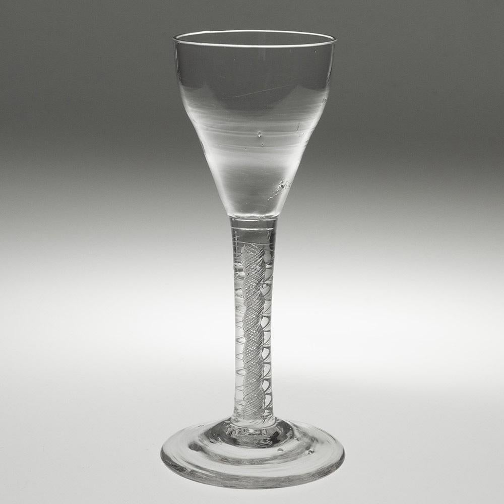 Heading : Georgian wine glass with mercury twist stem c1750
Period : George II
Origin : England
Colour : Clear
Bowl : Slightly ogee
Stem : A pair of 2-ply spiral tapes outwith a spiral gauze
Foot : Conical
Pontil : Snapped
Glass Type : Lead
Size :