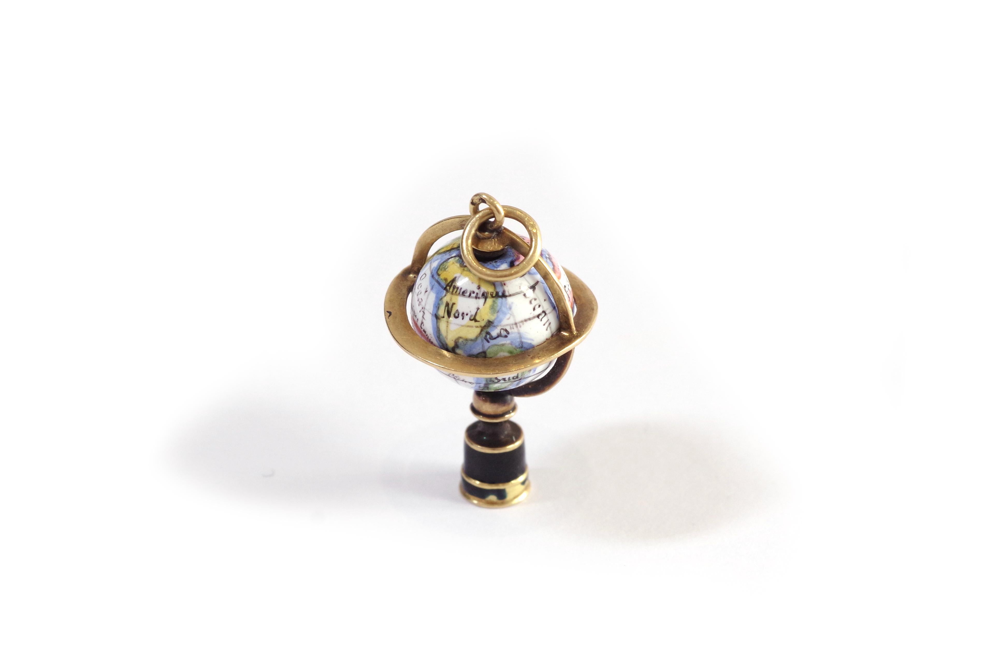 Breloque globe terrestre géorgien en 18 carats et émail. Pendentif ancien en forme de globe sur une base en émail noir. Le globe tourne sur lui-même, est émaillé et représente les continents (Afrique, Asie, Europe, Amérique du Nord, Amérique du Sud,
