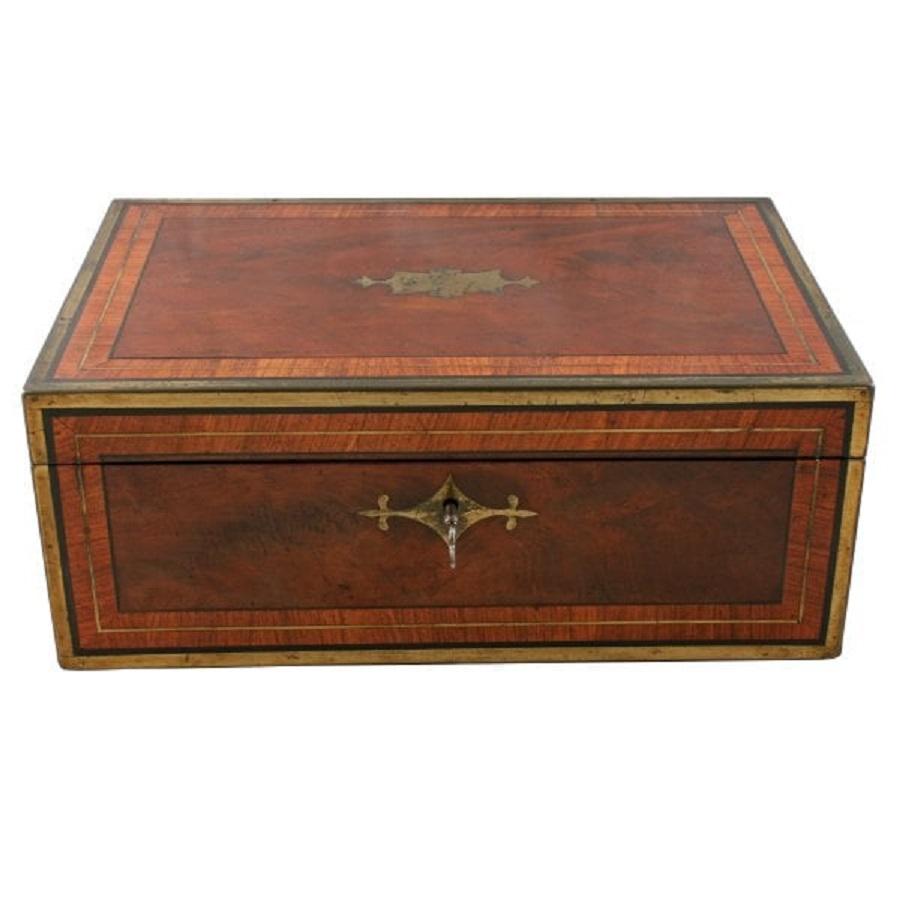 A Georgian mahogany writing box or box desk by Hicks of London.

The box is mahogany with brass edges, kingwood cross banding to the top and front, with heavy ebony line inlay.

The box has military style brass plate handles and a pair of brass