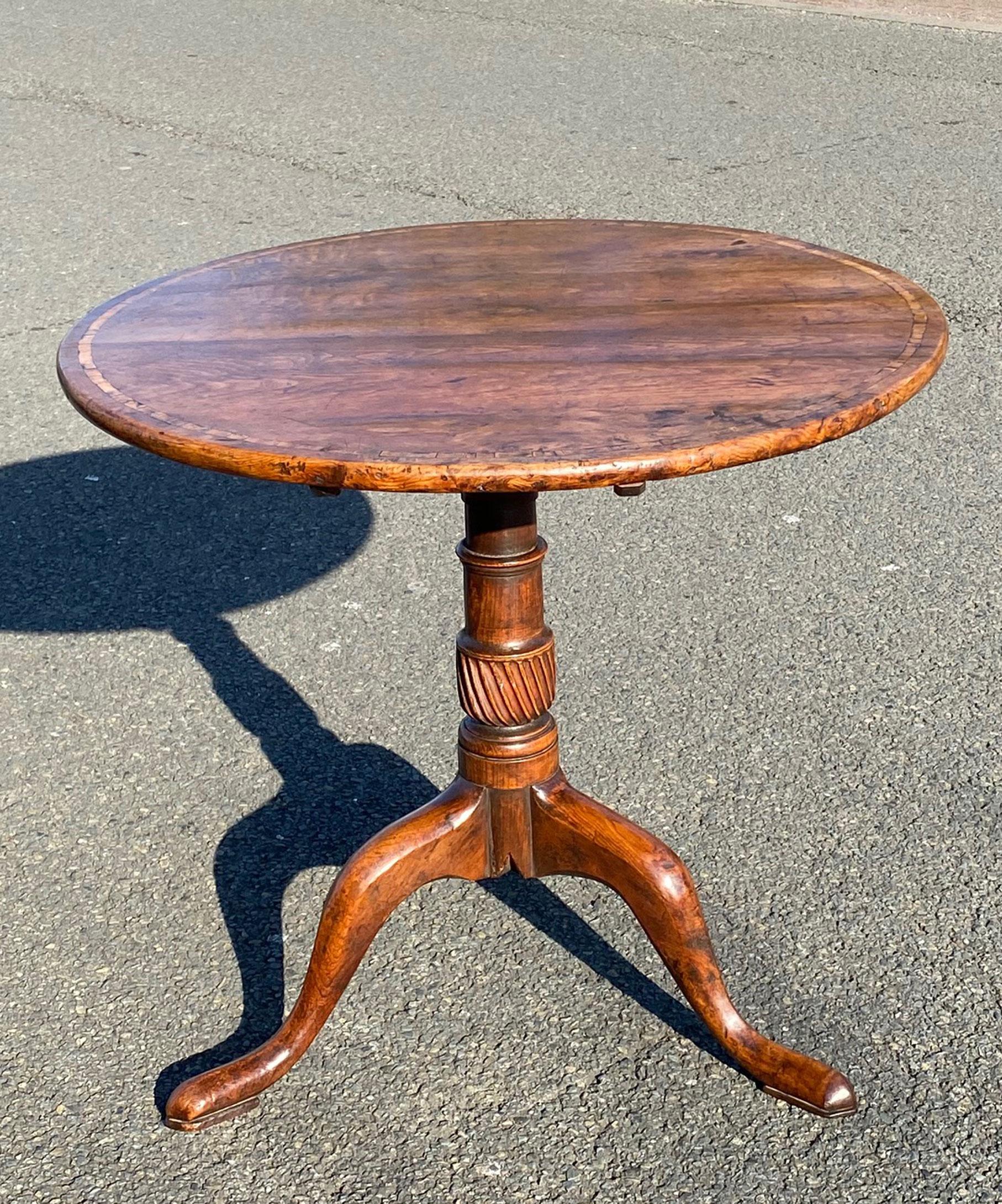 A beautifully patinated Georgian yew wood vernacular tripod table; the well figured tilt-top crossbanded in holly above a wrythen turned stem which is raised on well drawn cabriole legs terminating in shaped pad feet.

This tripod table retains a