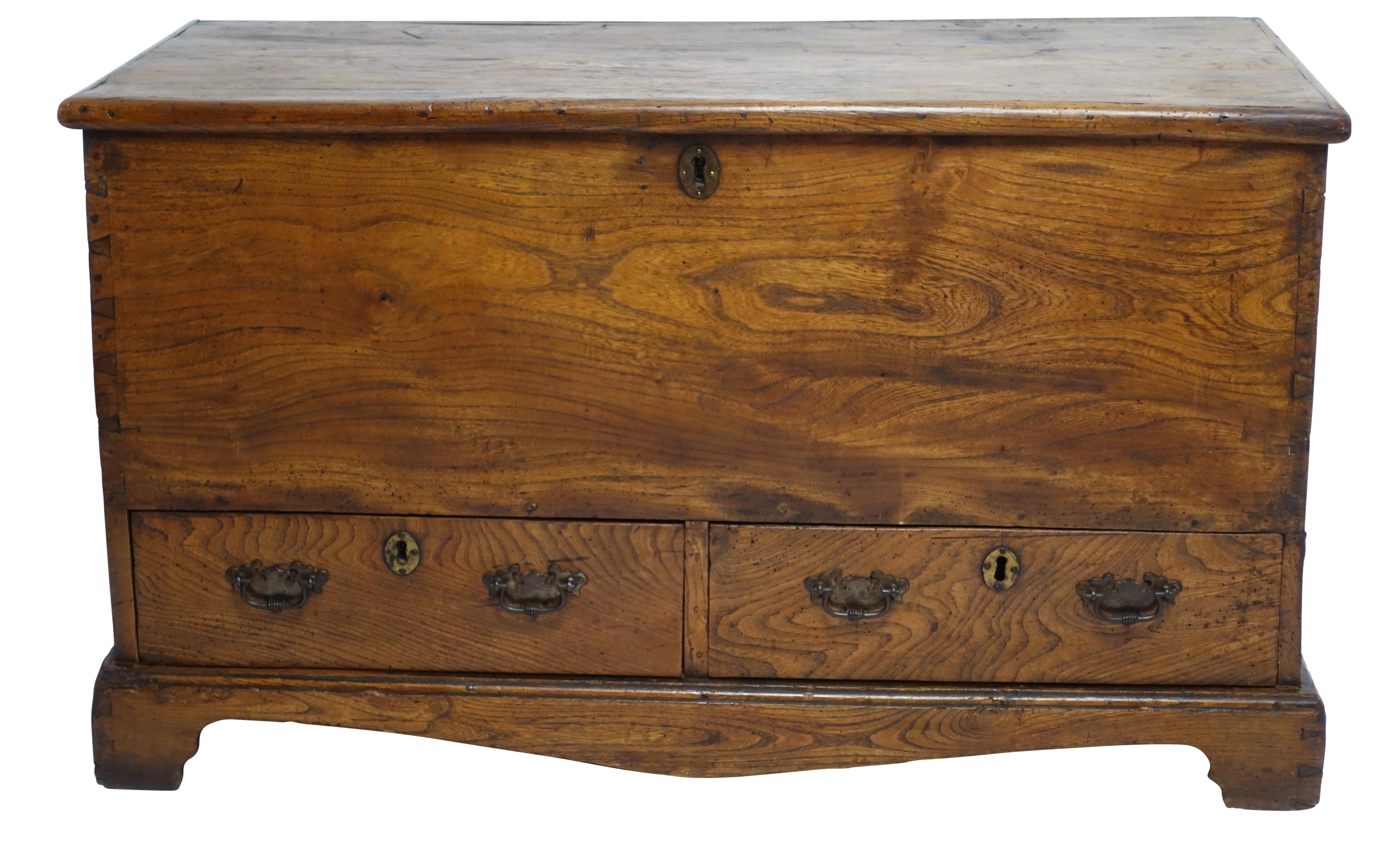 English yew wood trunk with two drawers, having lovely dovetailed corners and original brass escutcheons standing on a shapely base with bracket feet. England, circa 1800.