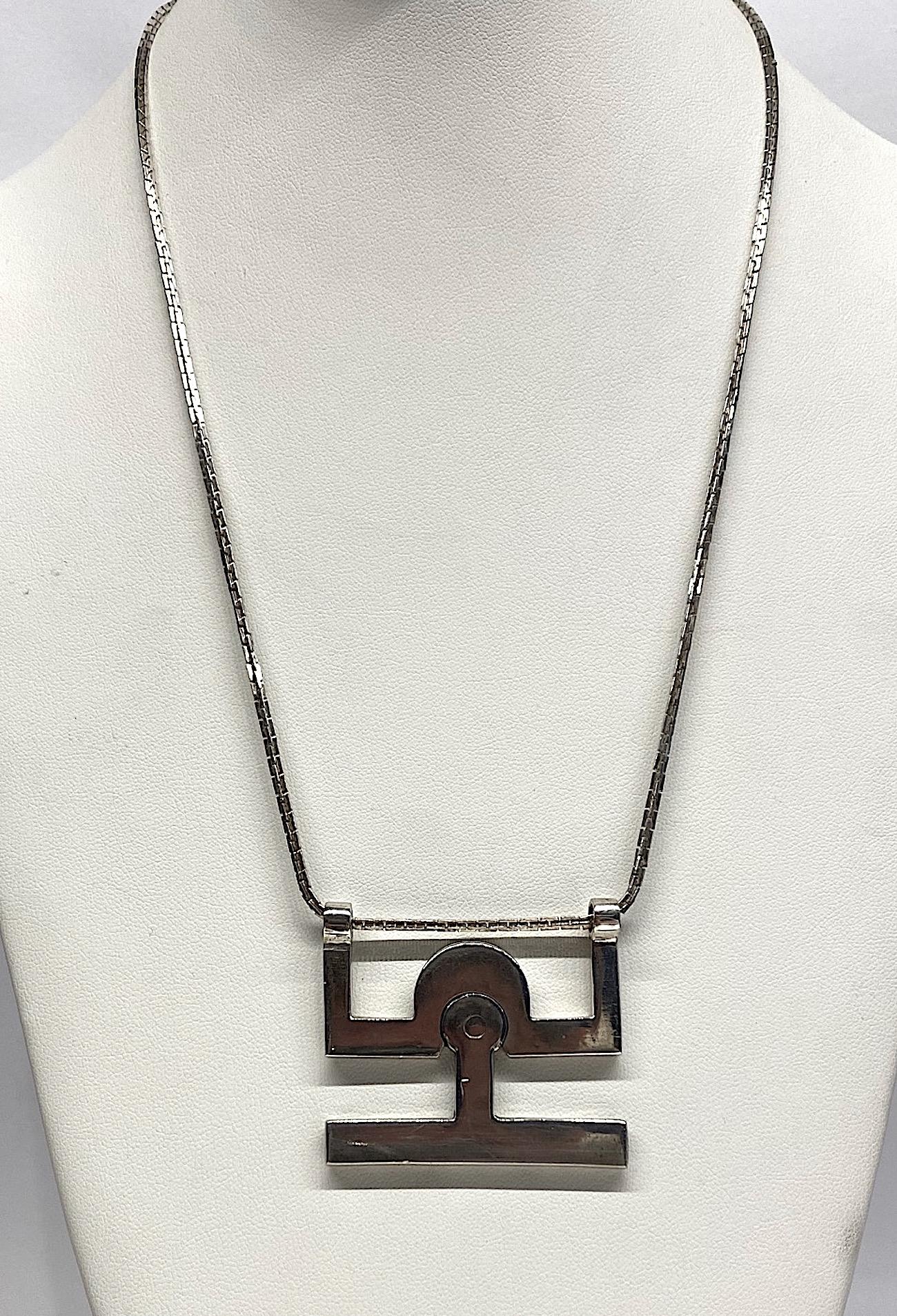 A modernist 800 silver pendant necklace by Giorgio Gucci, the grandson of Guccio Guccio of the famous Gucci fashion house. The articulated pendant is an abstract figure with arms up. The box link sterling chain goes through the hands and is 24.25