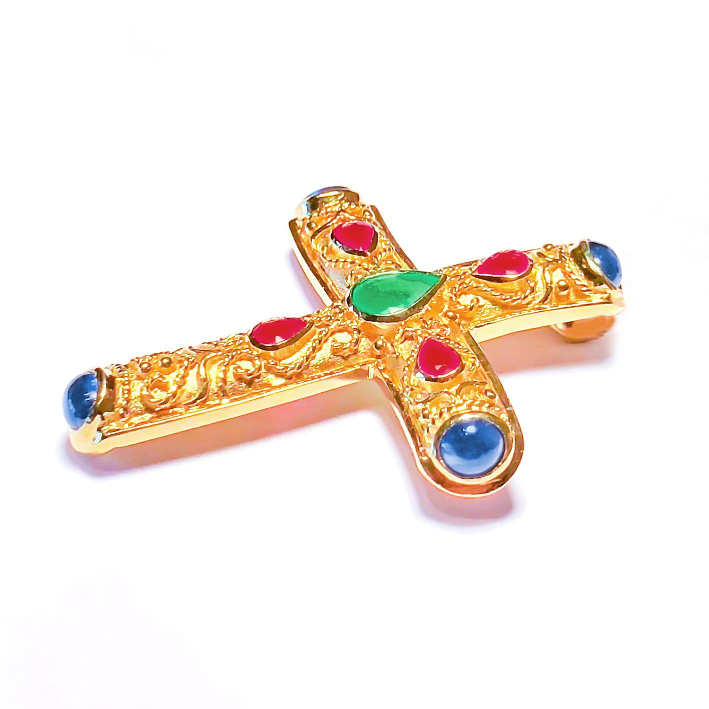 S.Georgios Byzantine Style Cross is handmade from solid 18 Karat Yellow Gold and features a Pear shape Emerald in the center, 4 Pear-shape Rubies, and 4 Blue Sapphires total weight of 4,00 Carats. This art piece is made as an inspiration from the