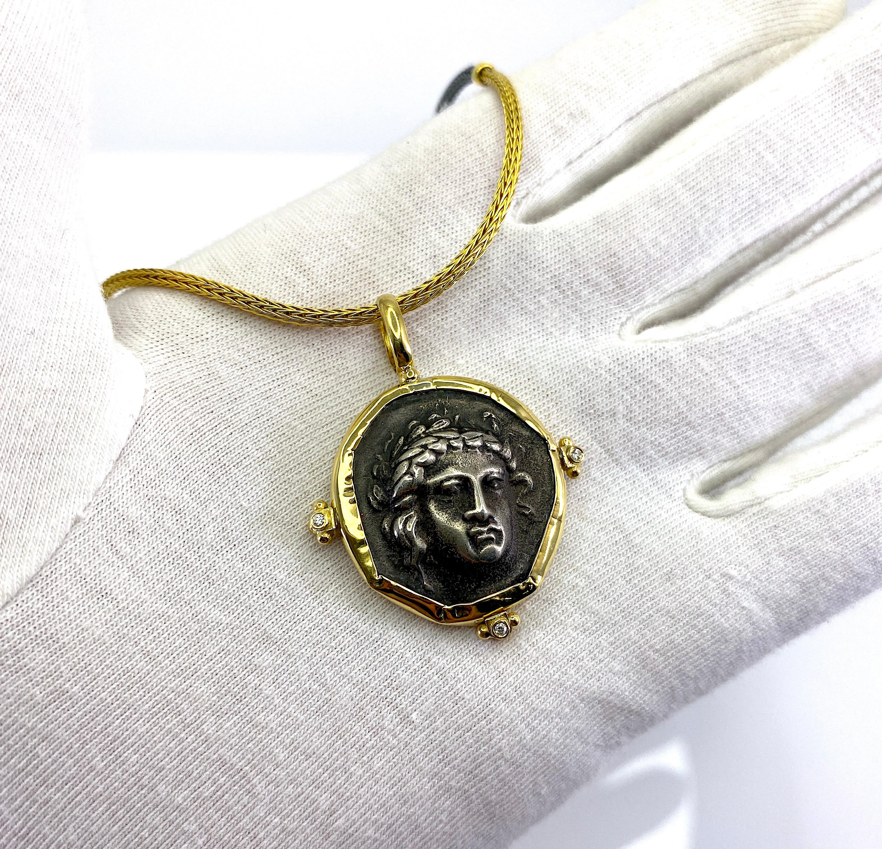 S.Georgios designer 18 Karat Yellow Gold handmade Pendant Necklace featuring a replica of an Ancient Greek Apollon Coin in Silver 925. The rim and hook of the pendant are solid 18 Karat Gold decorated with granulation work and 0.03 Carats of White