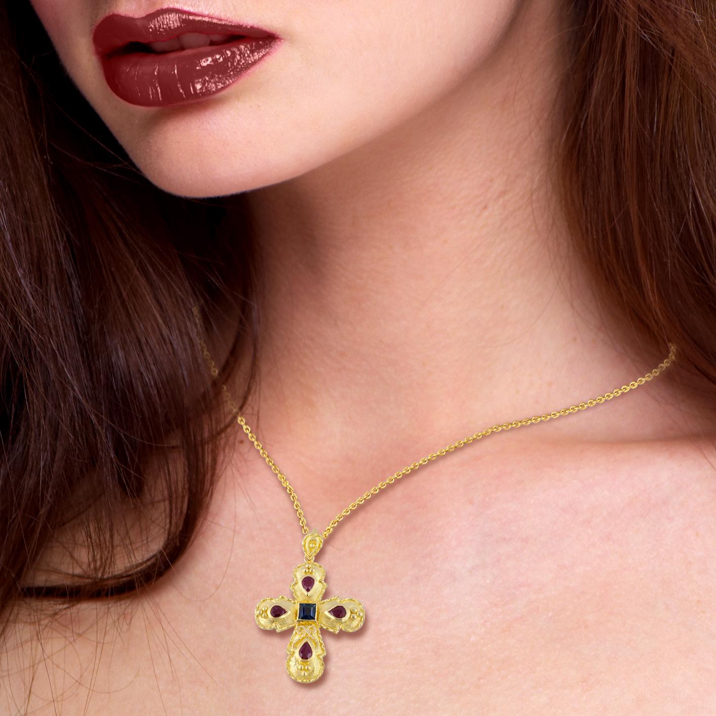 S.Georgios Byzantine Style Cross is handmade from solid 18 Karat Yellow Gold and features 4 Pear Share Rubies total weight of 1,05 Carat and a Sapphire total weight of 0,25 Carat. This art piece is made as an inspiration from the Byzantine Museum in