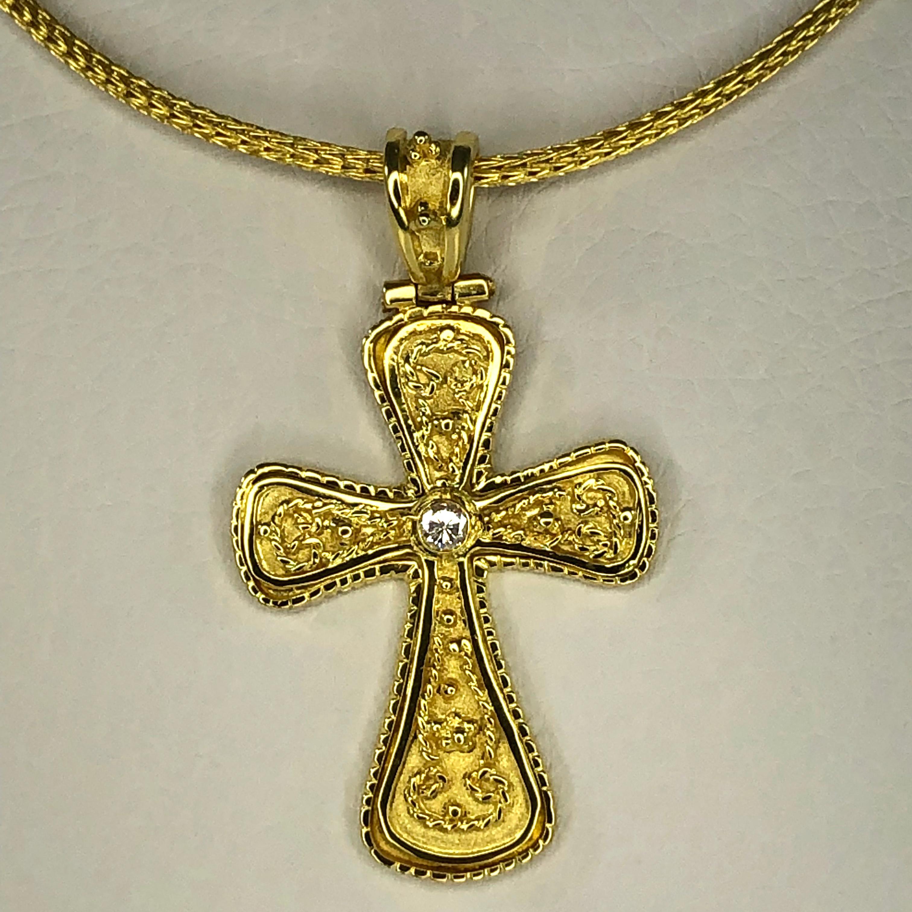 Le pendentif Croix de S.Georgios est entièrement réalisé à la main en or jaune 18 carats massif et est décoré de façon microscopique avec un travail de granulation sur tout le pourtour. Le fond de cette superbe croix a un aspect velours unique et