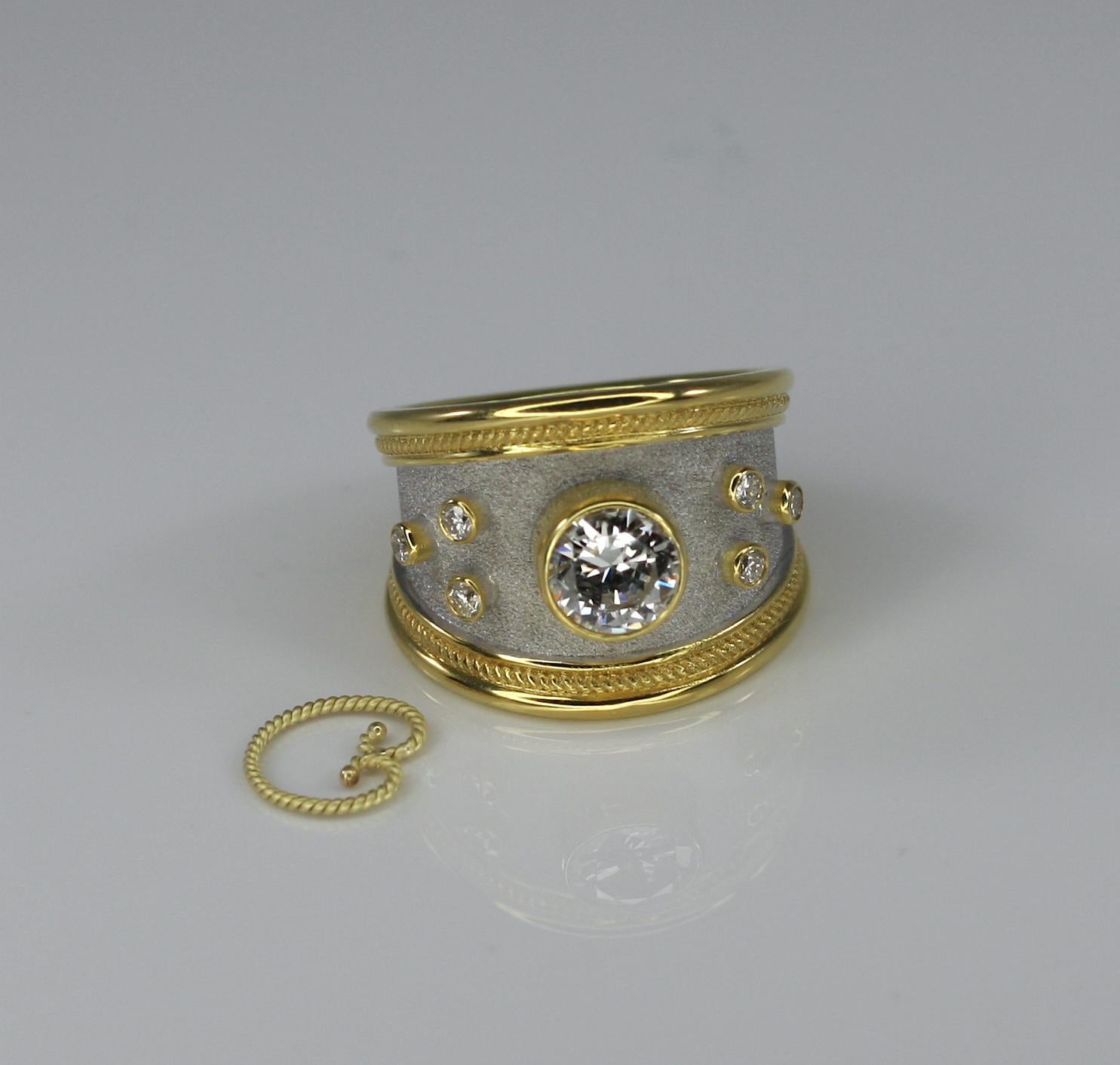 S.Georgios Design Ring handgefertigt aus massivem 18 Karat Gelbgold und weißem Rhodium. Dieses schöne Stück verfügt über einen zentralen weißen Diamanten im Brillantschliff von außergewöhnlicher Qualität VS 2 und Farbe F. Der zentrale Stein wird