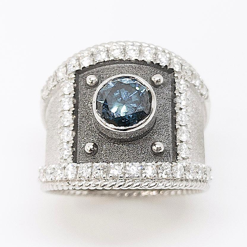 S.Georgios designer offers this outstanding ring handmade from solid 18 Karat White Gold and decorated with granulation details and a velvet background in Byzantine style. The front square surrounding the 1.05 Carat Brilliant cut Blue diamond is