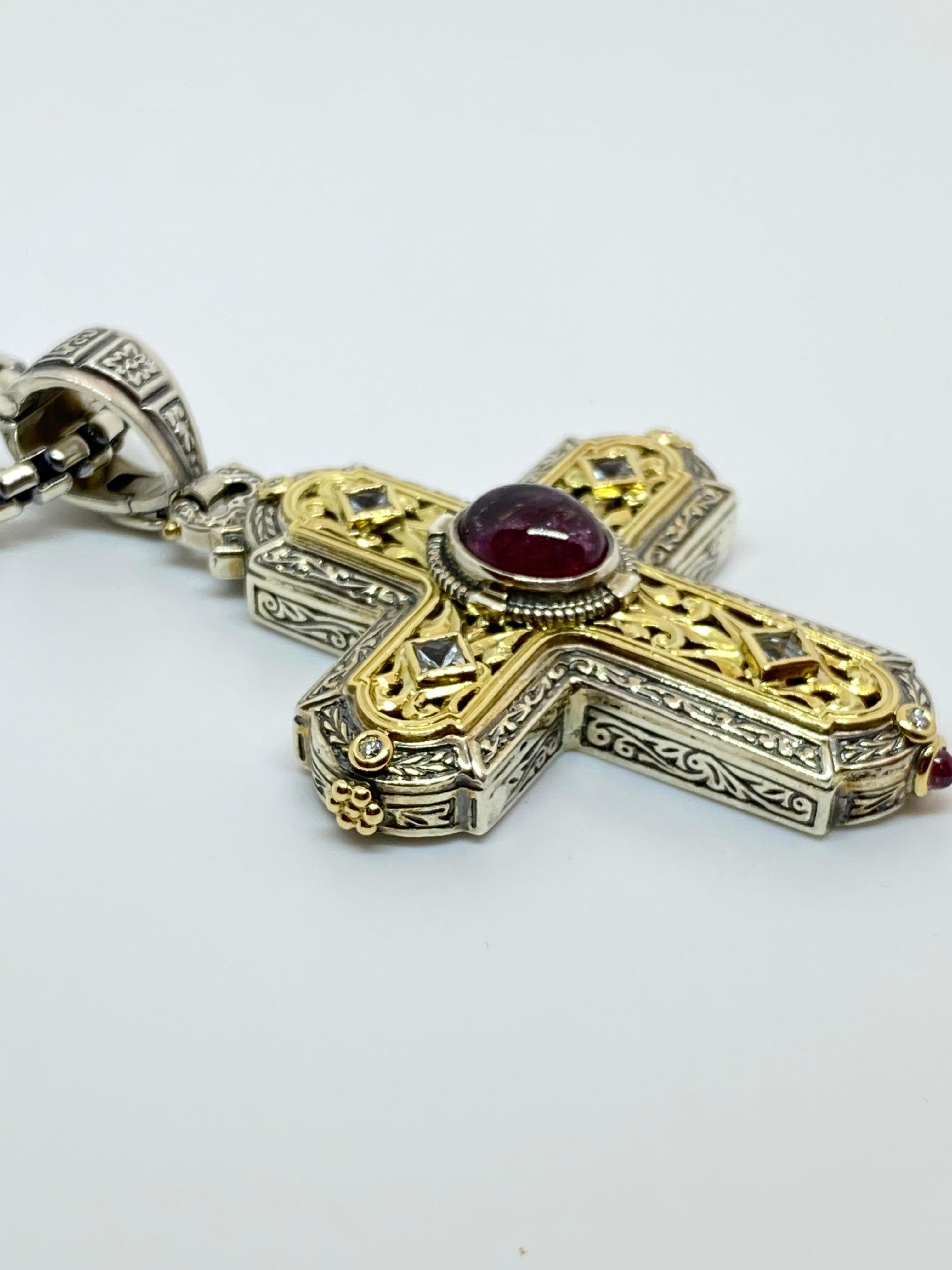 S.Georgios designer Silver and Gold 18K Cross pendant crafted from sterling silver 925 and solid 18 Karat yellow gold inlay to create a unique look. This gorgeous cross enhancer features 4 Diamonds total weight of 0.16 Carat, 2 Ruby cabochon the