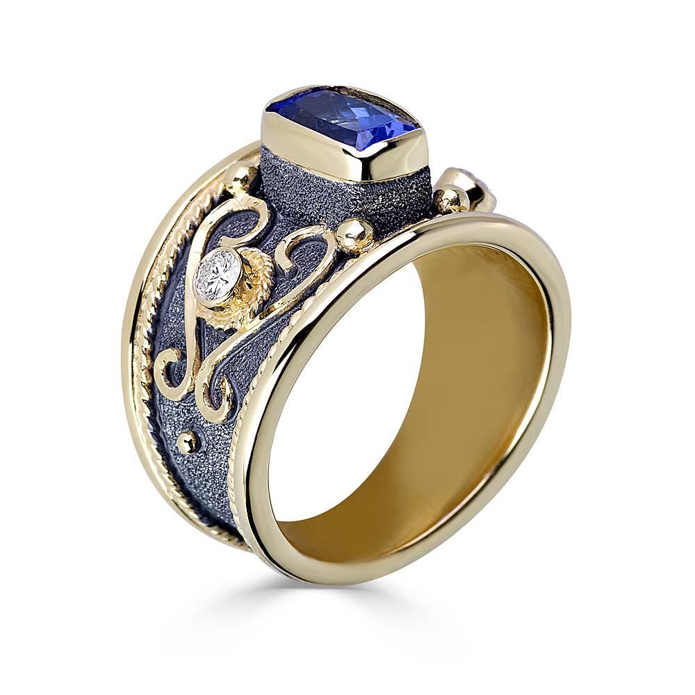 S.Georgios Designer Hand Made 18 Karat Gold Two-Tone Ring features 2 Brilliant Cut White Diamonds total weight of 0.20 Carat and a center 1.85 Carat Cushion Cut Natural Tanzanite. The beautiful ring is richly decorated with Byzantine-era style